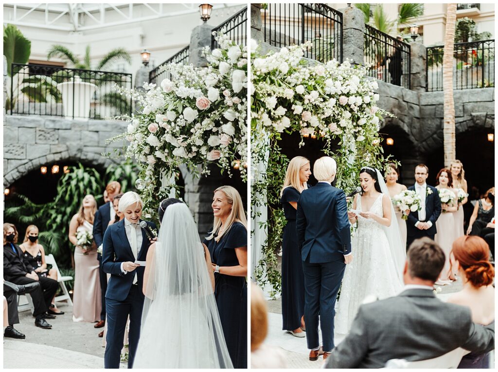 two women read wedding vows on floral altar at garden-themed wedding