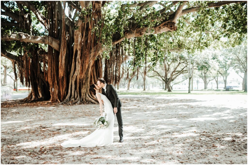 bride and groom kiss in front of tree at St. Petersburg Museum of Fine Arts wedding; romantic wedding portrait 