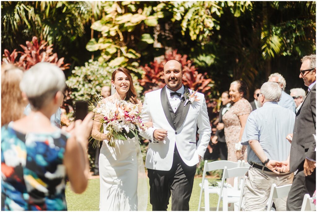 Bride and groom lead recessional during outdoor garden wedding in Tampa Florida