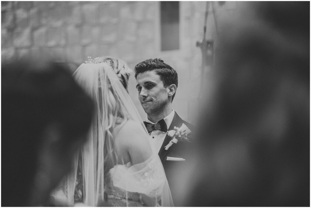 black-and-white candid photo of groom looking into bride's eyes and smiling; romantic portrait of couple during wedding at The Vinoy in St Pete