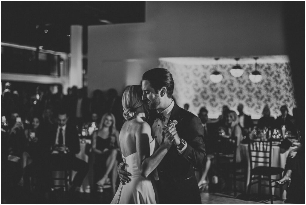 Black and white photo of bride and groom in embrace during first dance at Hyde House Tampa 