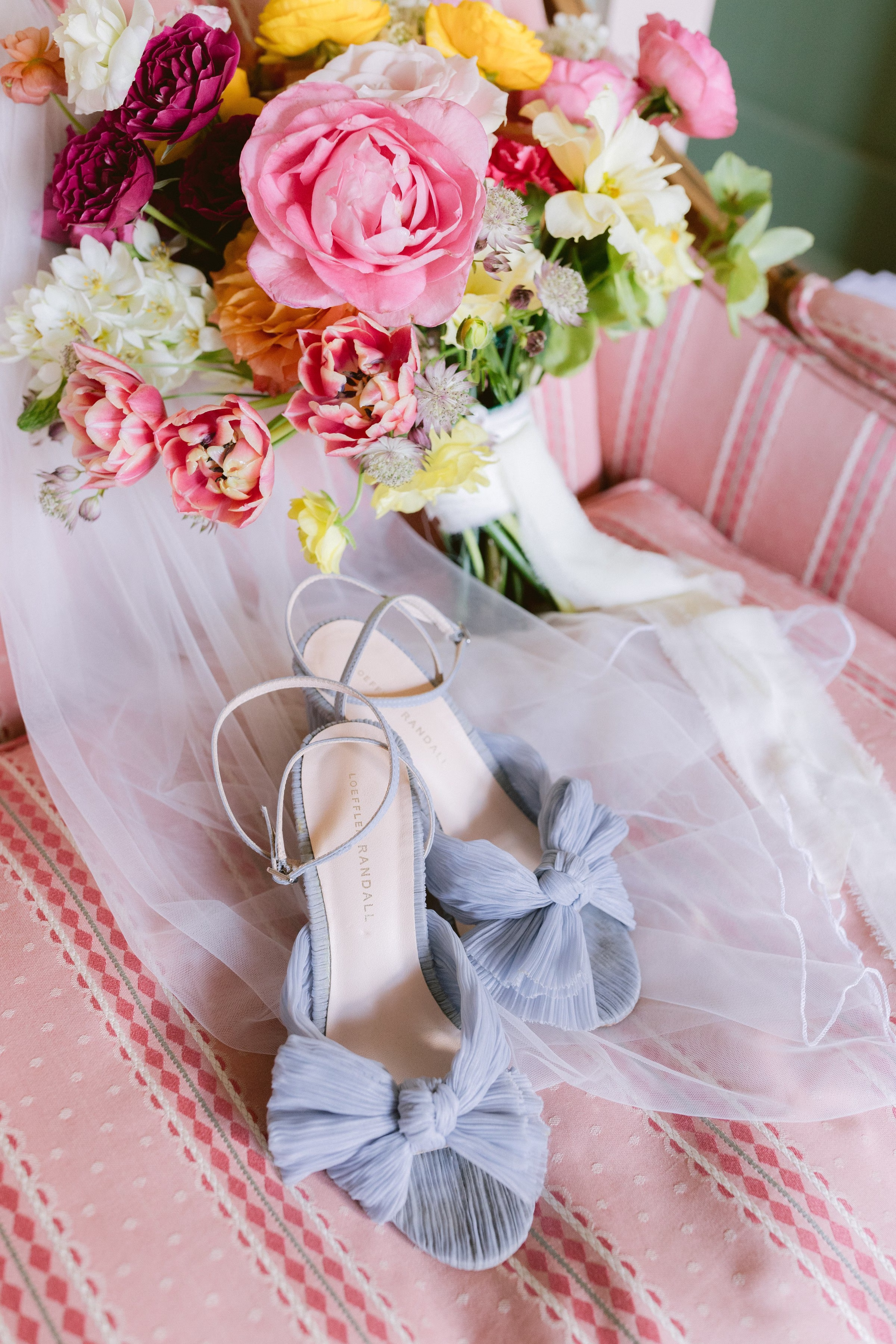 Colorful bridal bouquet with pink ranunculus and blue bow wedding shoes captured by Tampa Bay wedding photographer Ashley Izquierdo Photography