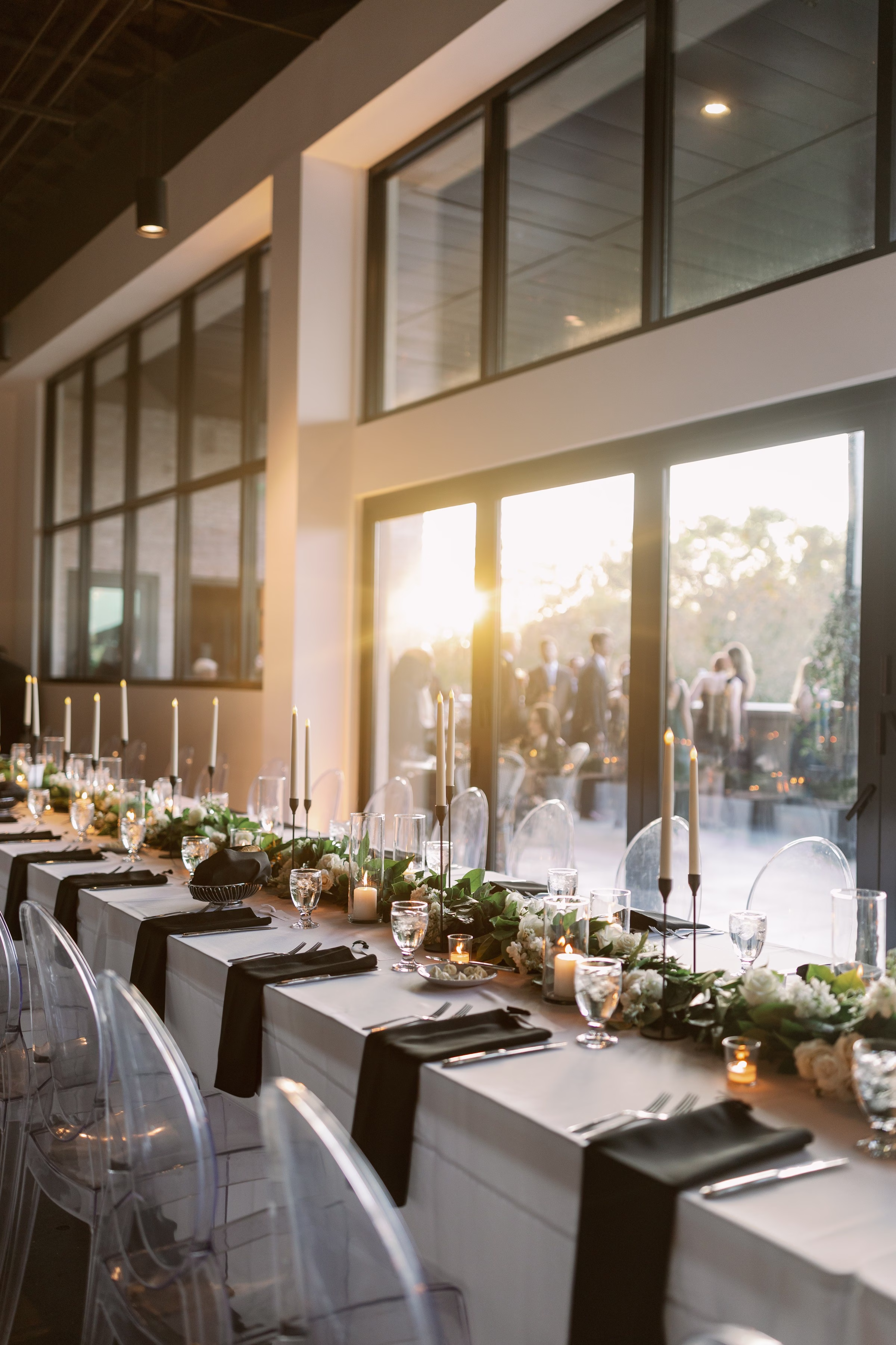 Elegant wedding reception tablescape with white florals, tall candles and clear ghost chairs at modern Tampa Bay venue by Ashley Izquierdo Photography