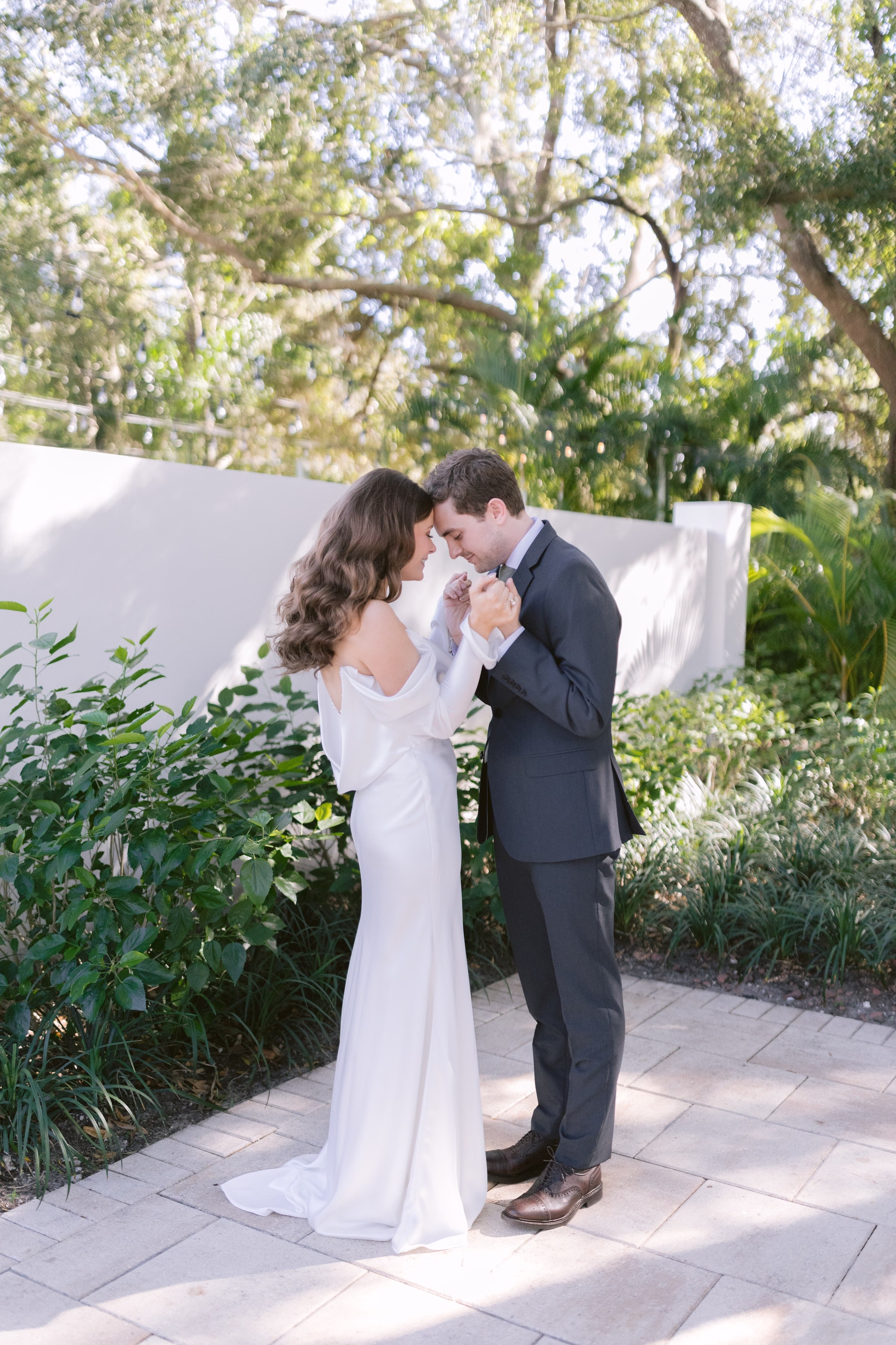 Romantic first look moment between bride and groom in elegant garden setting captured by Tampa Bay wedding photographer Ashley Izquierdo Photography