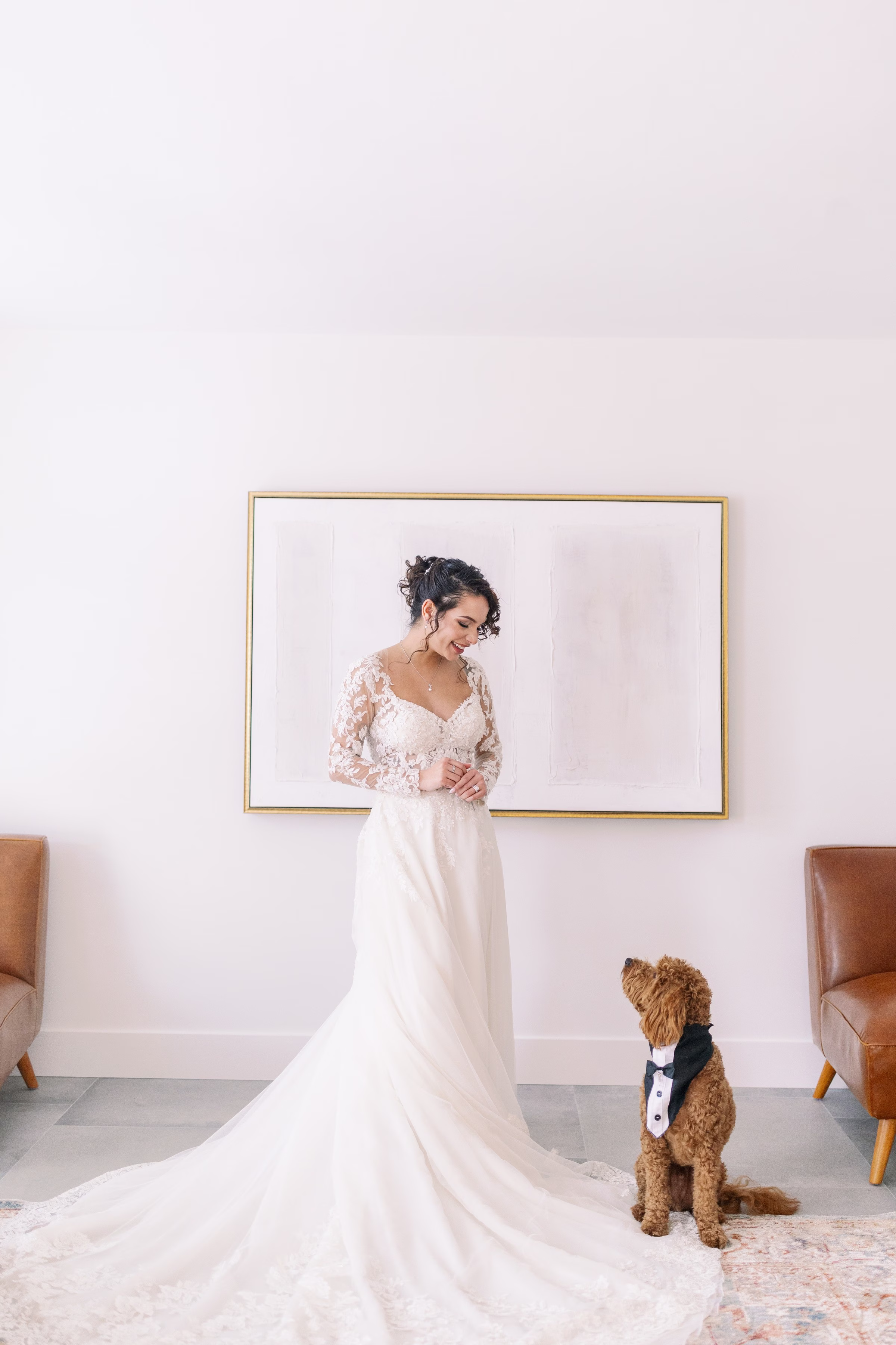 Elegant bride in lace wedding gown poses with dog in formal attire during Tampa Bay wedding photography session by Ashley Izquierdo Photography