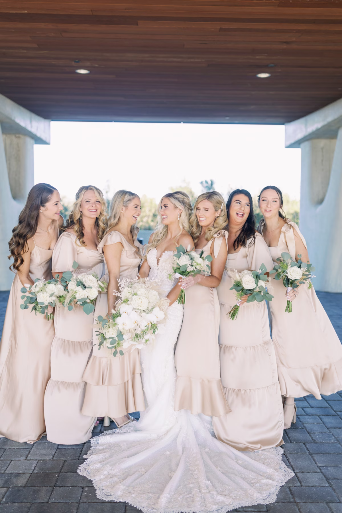 Tampa Bay bride with six bridesmaids in blush pink dresses holding white and greenery bouquets photographed by Ashley Izquierdo Photography