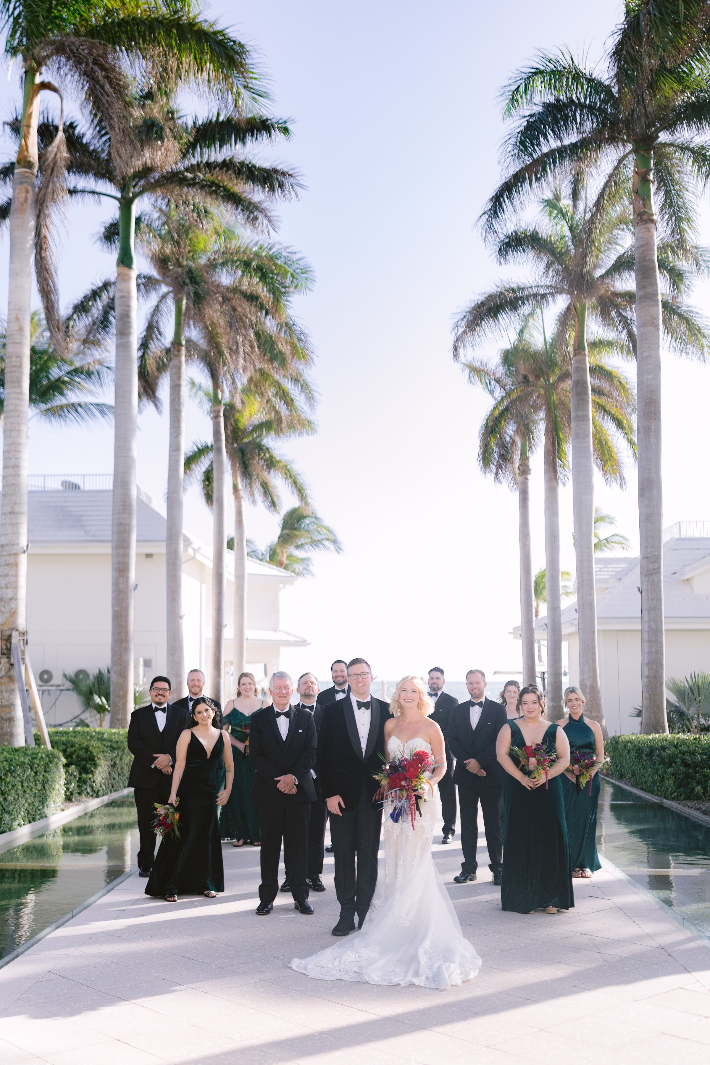tropical wedding party portrait palm trees ashley izquierdo photography tampa bay photographer - Home Wedding party portrait with bride groom and wedding party in formal attire standing among tall palm trees at tropical Tampa Bay venue