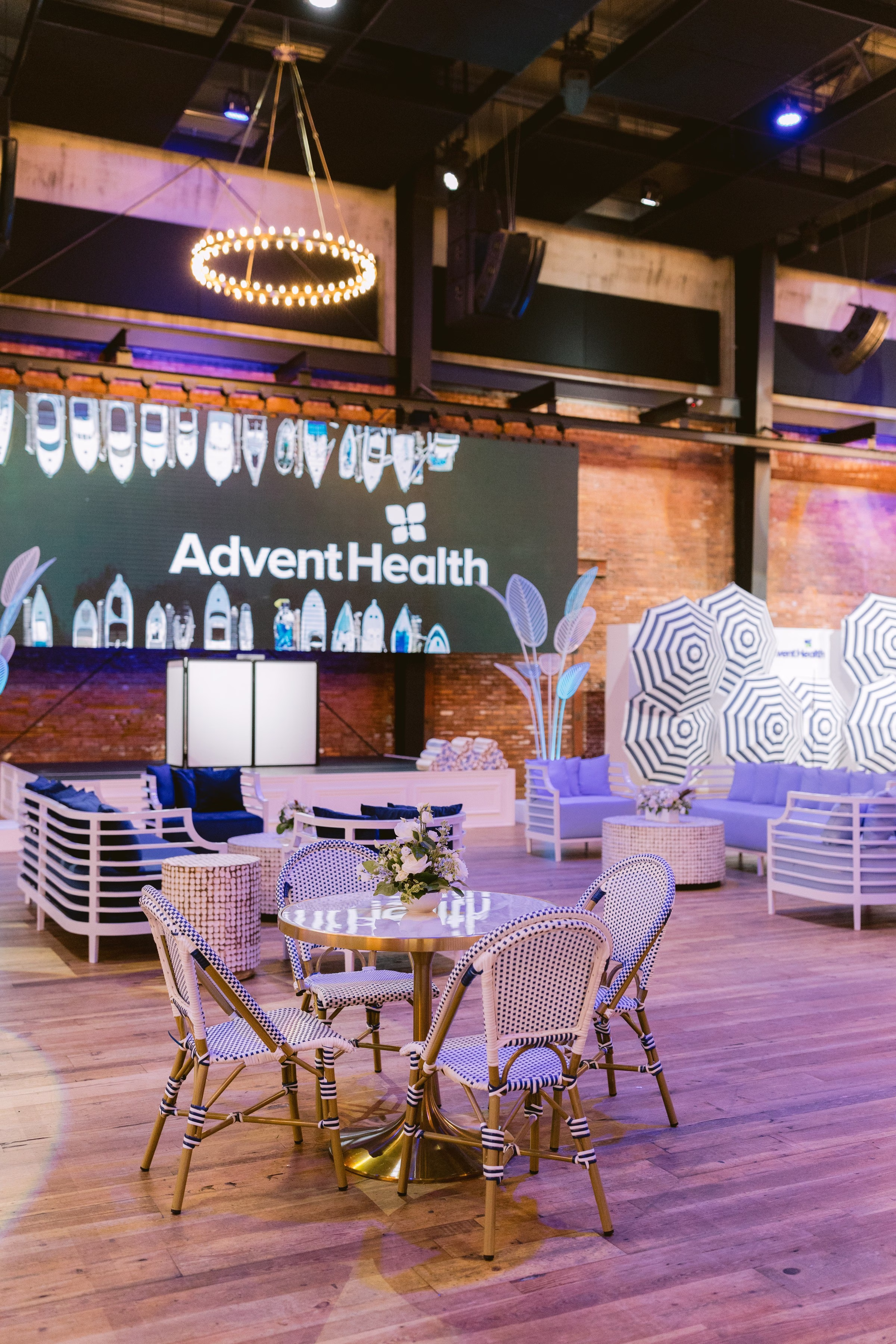 Corporate event setup with modern seating area and Advent Health branding at Tampa Bay venue photographed by Ashley Izquierdo Photography