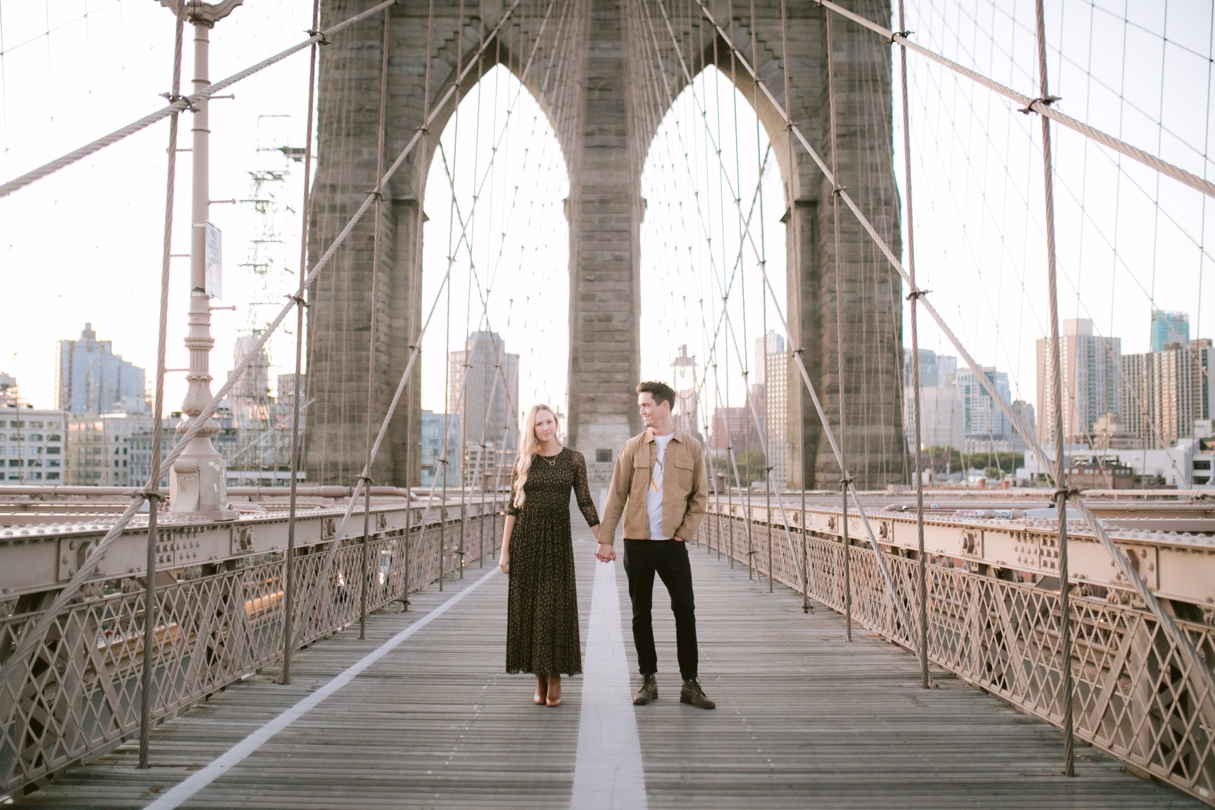 Romantic engagement session on Brooklyn Bridge walkway with New York City skyline backdrop by Tampa Bay wedding photographer Ashley Izquierdo Photography