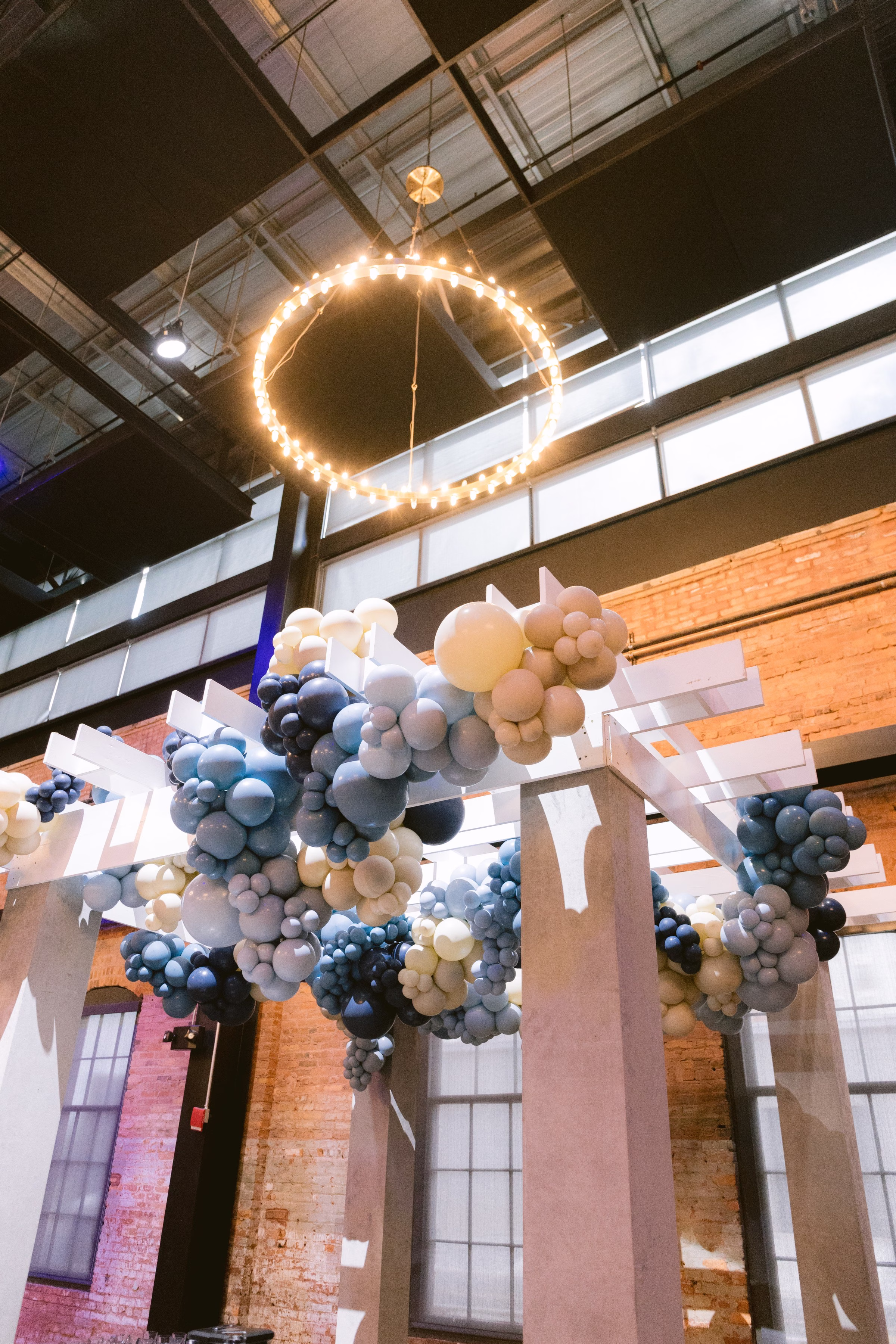 Corporate event balloon installation with blue and white balloons under string lights captured by Tampa Bay photographer Ashley Izquierdo Photography