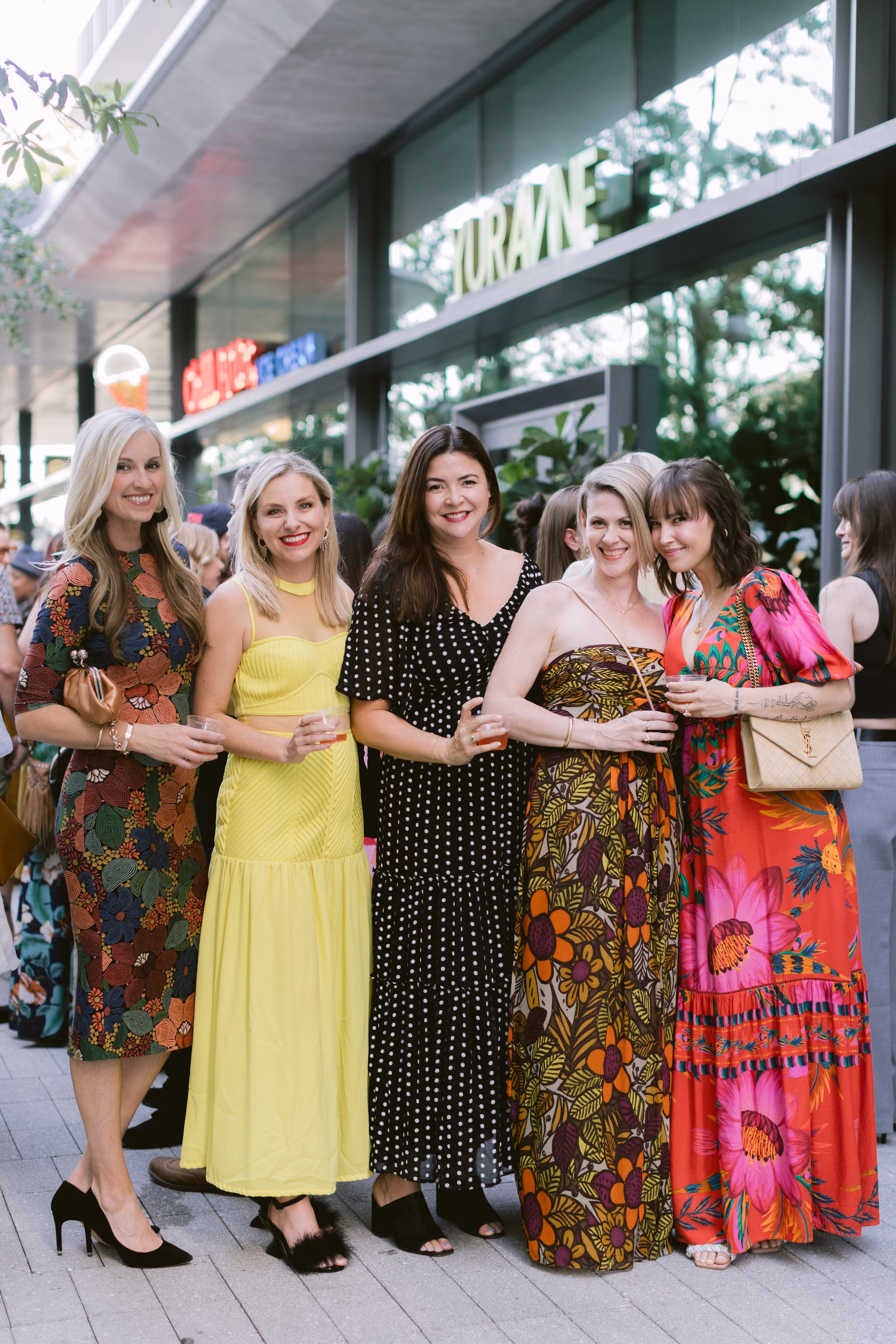 Corporate event photography capturing group of women in colorful dresses at outdoor Tampa Bay gathering by Ashley Izquierdo Photography