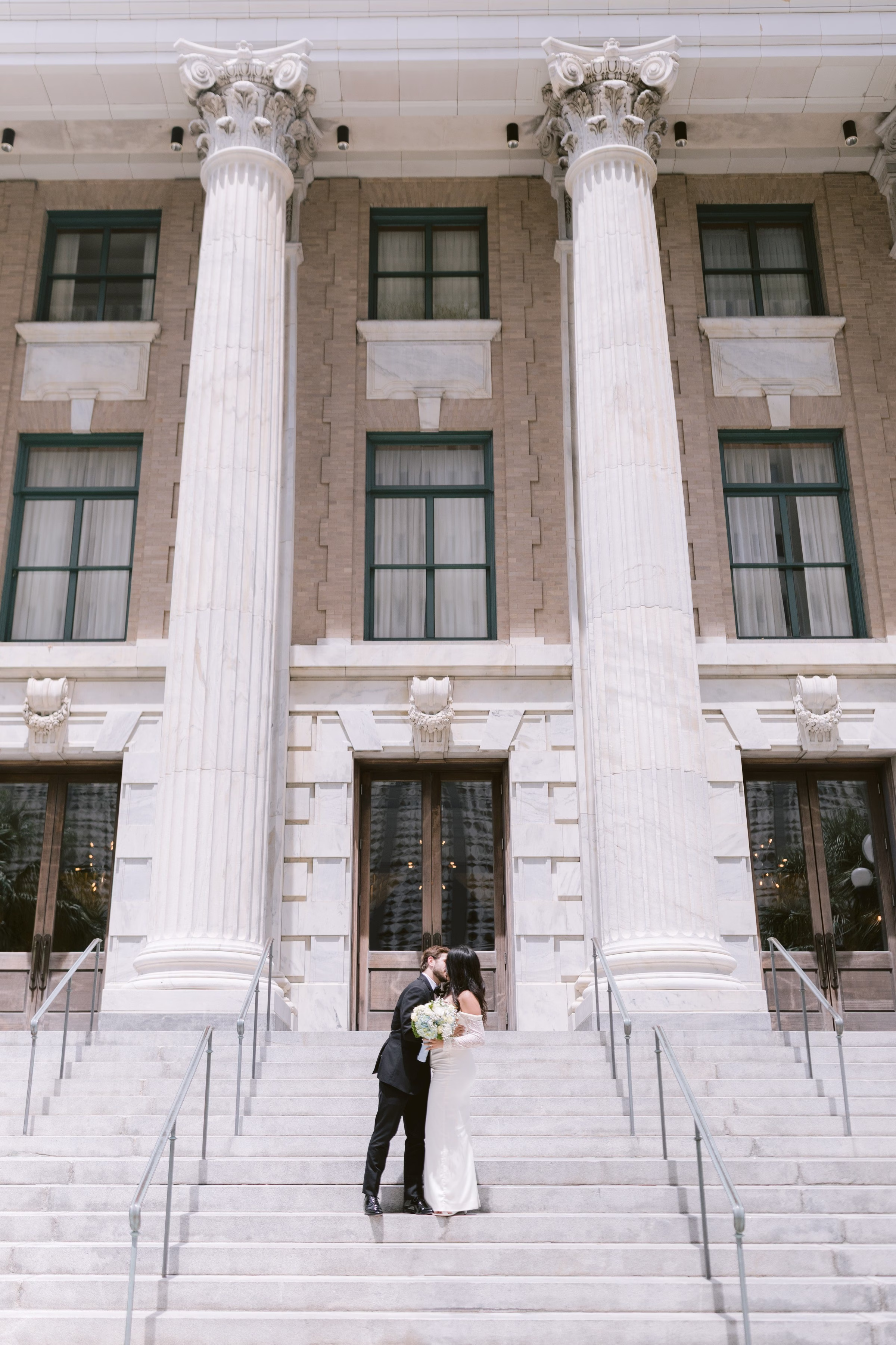 courthouse elopement wedding photography tampa bay classic columns - Home Bride and groom sharing intimate moment on courthouse steps with grand white columns during Tampa Bay elopement captured by Ashley Izquierdo Photography