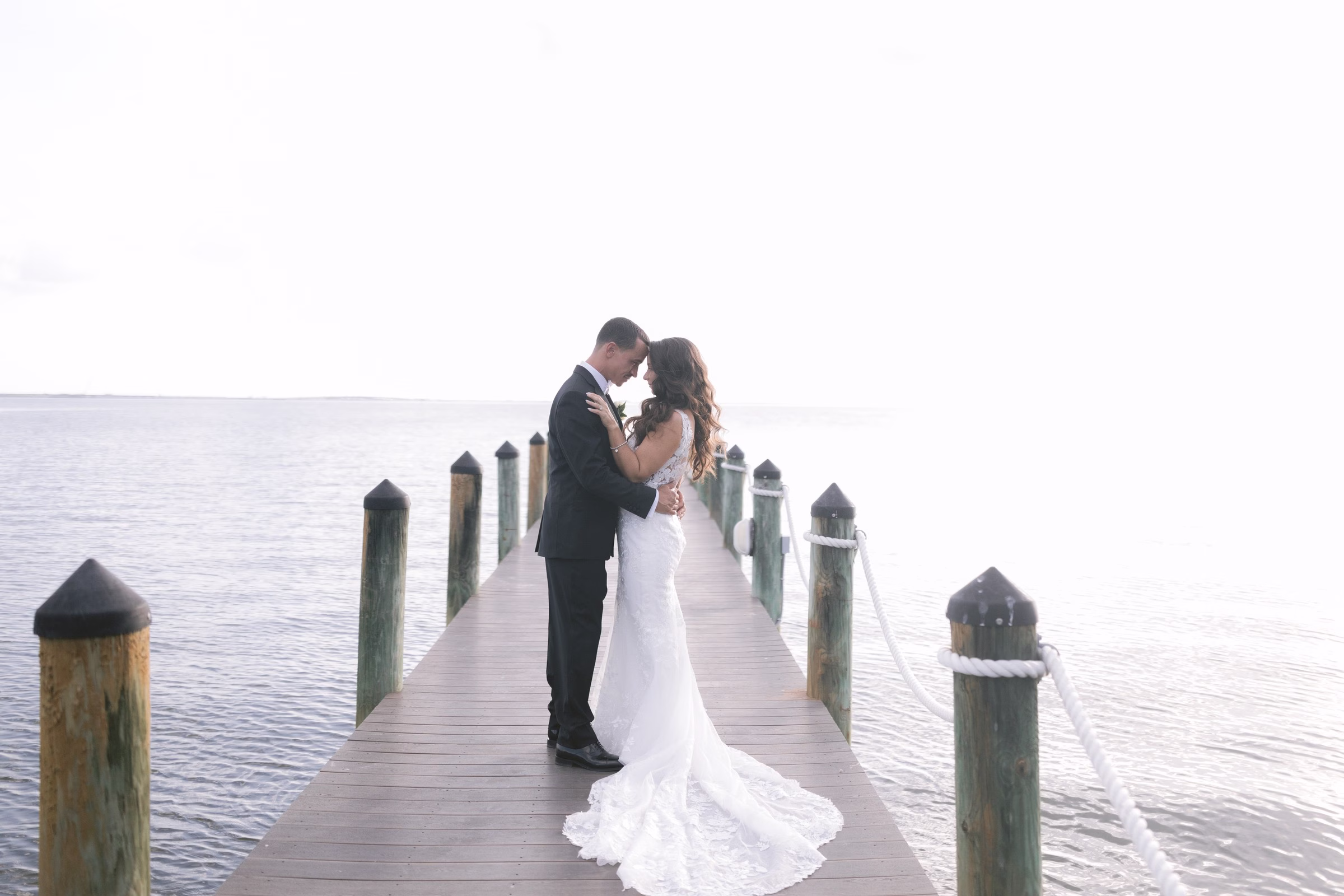 grand hyatt tampa bay waterfront dock wedding portrait - Tampa Bay Wedding Venues Bride and groom sharing intimate moment on wooden dock overlooking Tampa Bay at Grand Hyatt Tampa Bay wedding venue