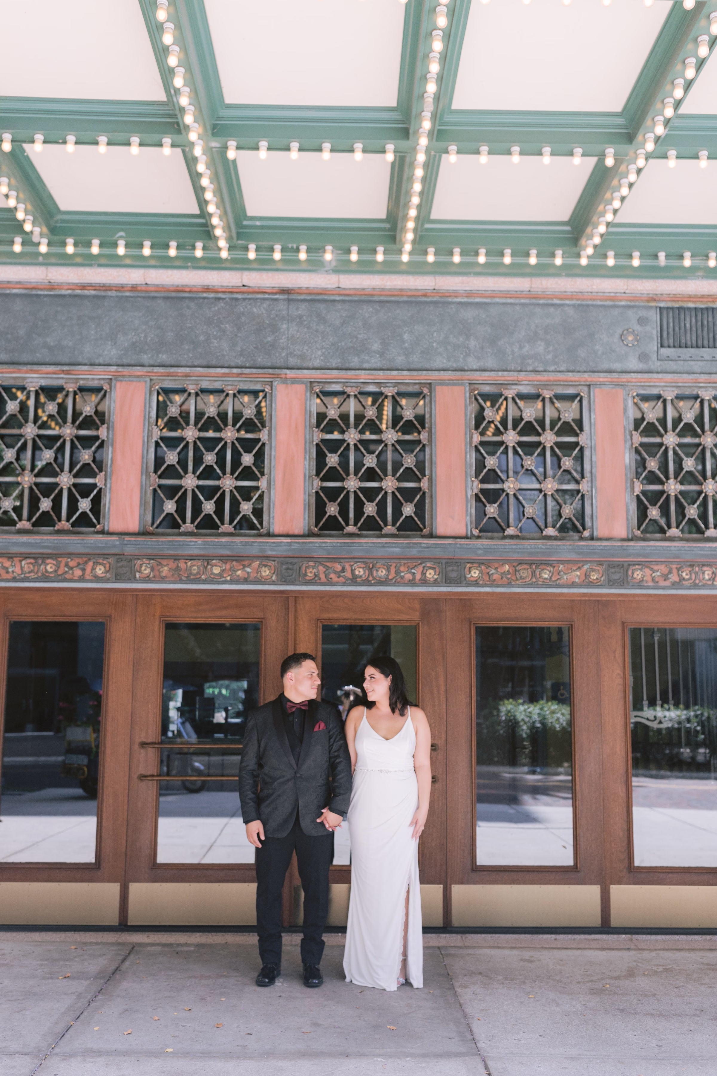 Bride and groom sharing intimate moment under historic theater marquee lights during Tampa Bay elopement