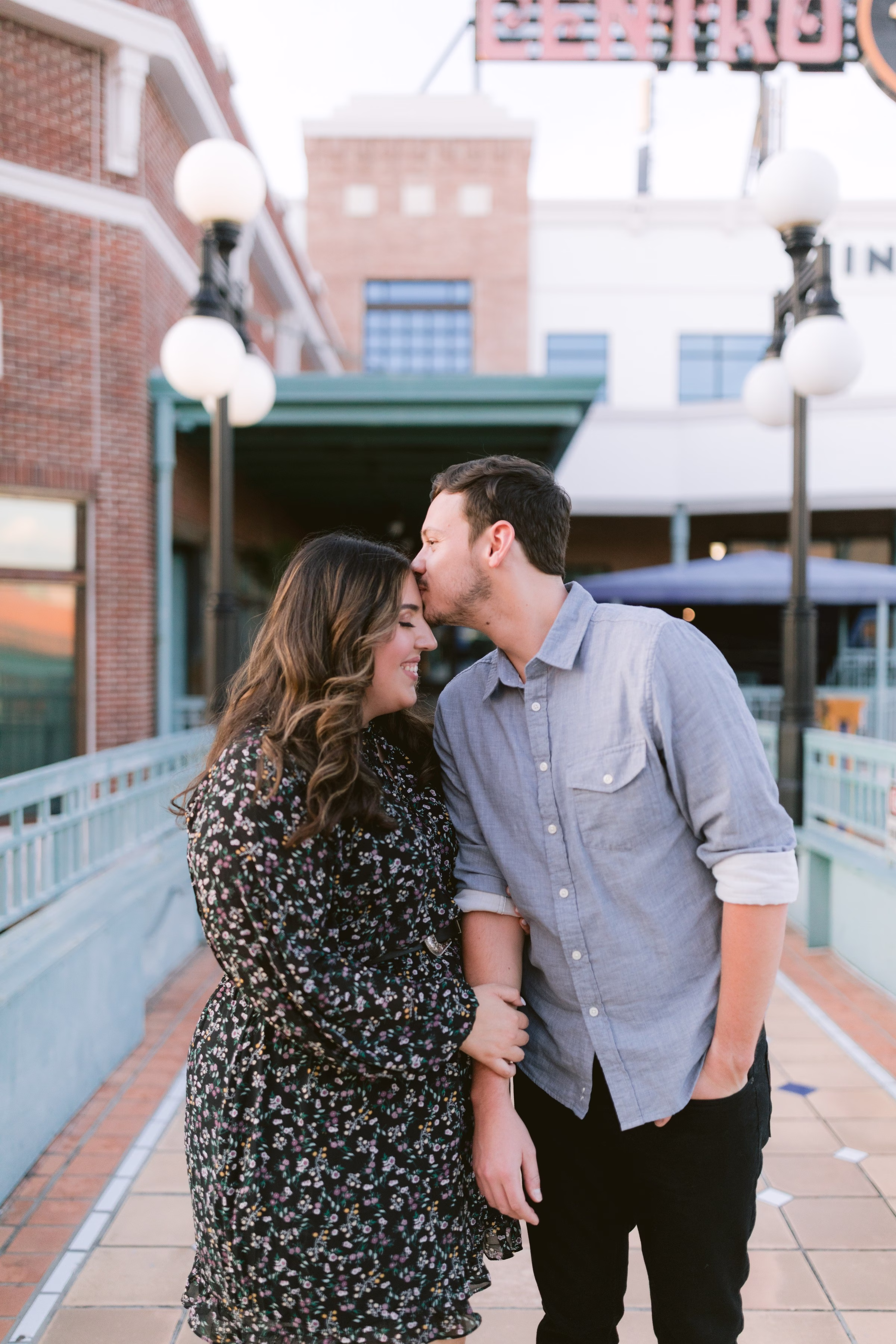 Romantic engagement session in Tampa Bay historic downtown district featuring couple in intimate pose with brick buildings and string lights by Ashley Izquierdo Photography