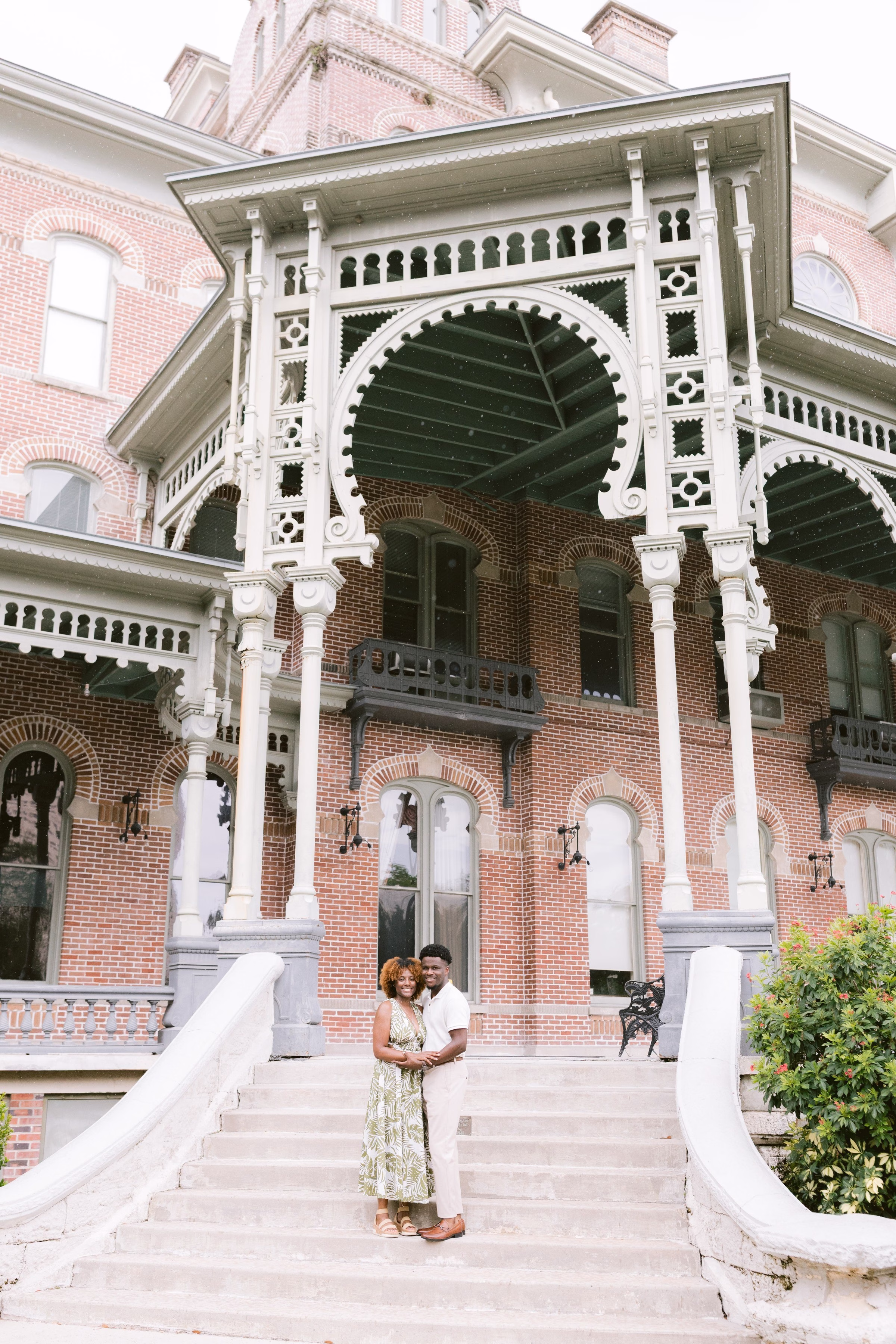 Elegant engagement session at historic Victorian mansion in Tampa Bay featuring ornate white columns and red brick architecture by Ashley Izquierdo Photography