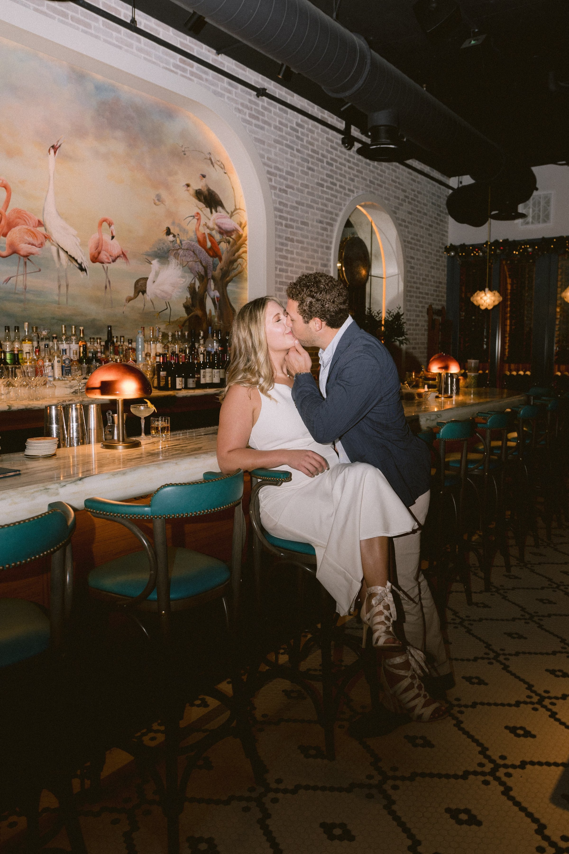 Romantic engagement session at upscale Tampa Bay bar with flamingo mural and elegant interior design by Ashley Izquierdo Photography