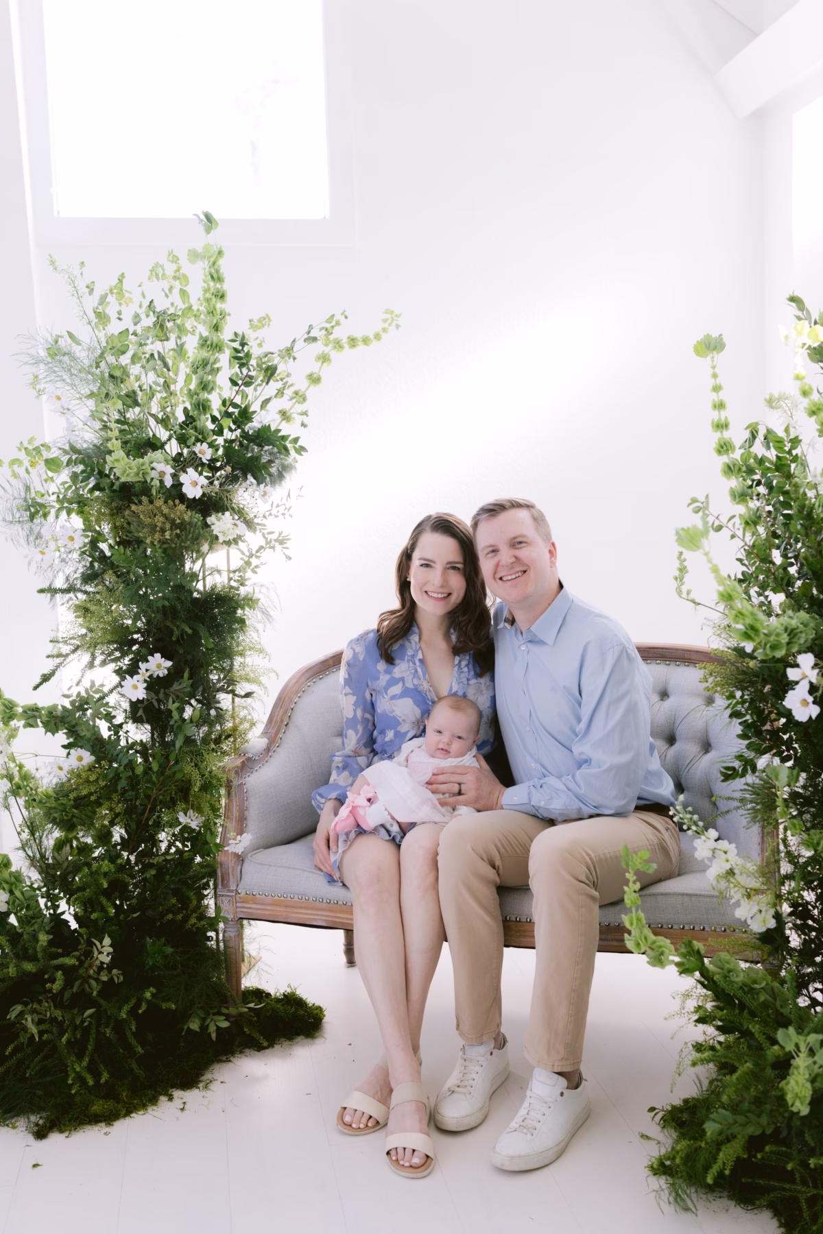 Tampa Bay family portrait session with newborn baby surrounded by lush greenery and white flowers by Ashley Izquierdo Photography
