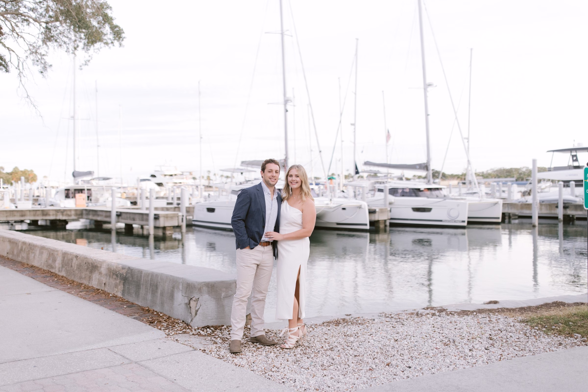 Elegant couple poses at Tampa Bay marina during romantic engagement session by Ashley Izquierdo Photography