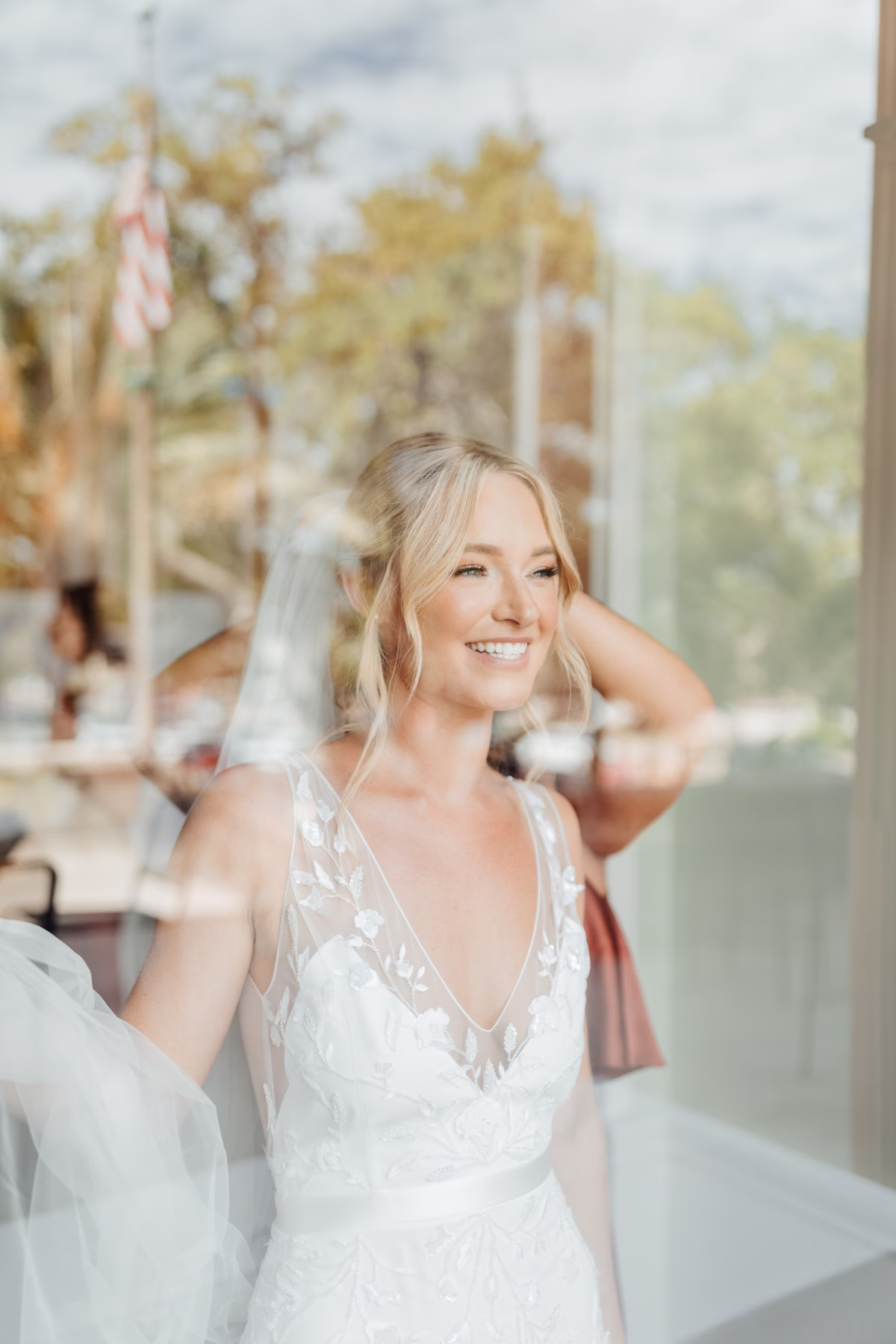 Bride in Alexandra Grecco wedding dress smiling during portrait session at The Lightner Museum in St Augustine photographed by Ashley Izquierdo Photography