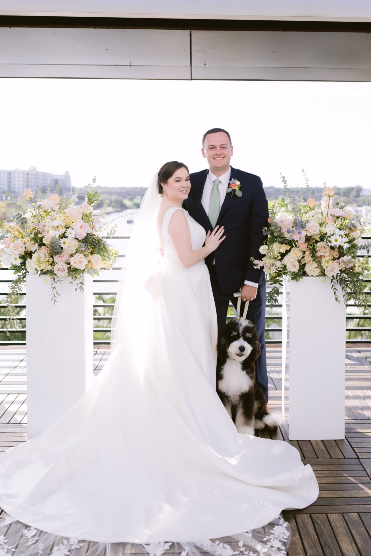 Bride and groom with their dog at Armature Works wedding ceremony featuring floral arrangements by I Dew Events in Tampa