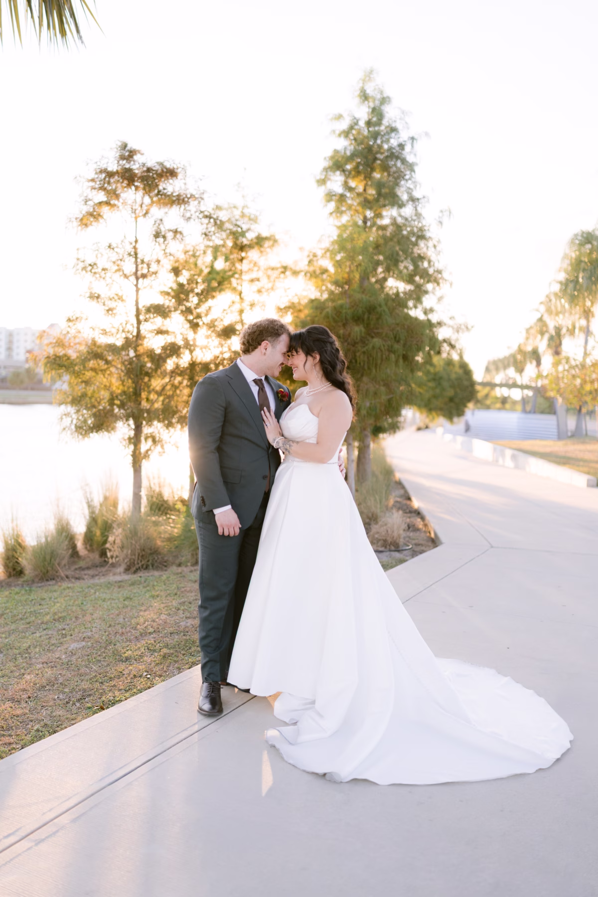 Bride and groom sharing intimate moment at golden hour wedding portrait session at Armature Works Tampa with wedding planning by Seashine Weddings
