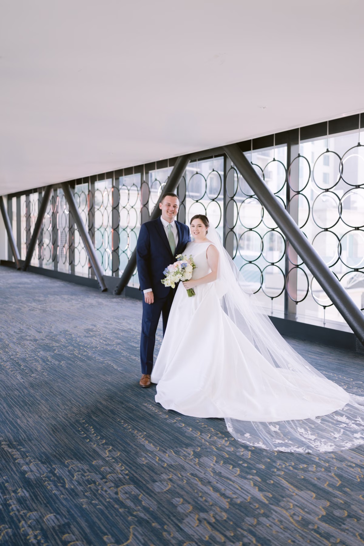 Bride and groom wedding portrait at Armature Works Tampa with white bridal bouquet by I Dew Events florist and wedding dress from The White Closet Bridal