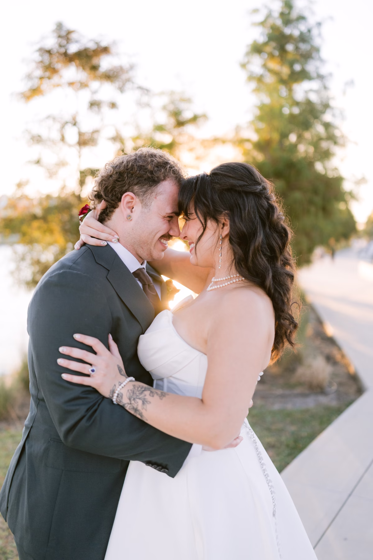 Newlywed couple embracing during golden hour portrait session at Armature Works Tampa wedding planned by Seashine Weddings