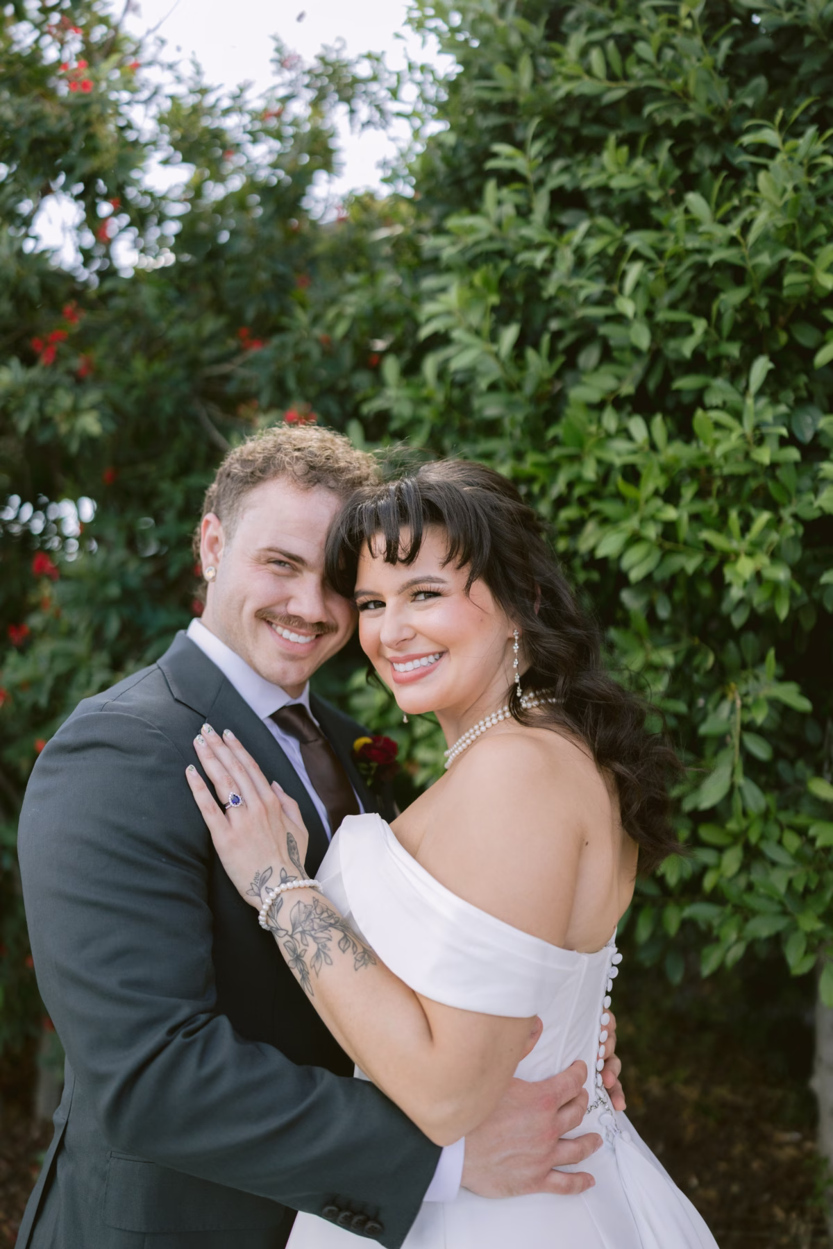 Bride and groom embracing in garden setting at Armature Works Tampa wedding coordinated by Seashine Weddings