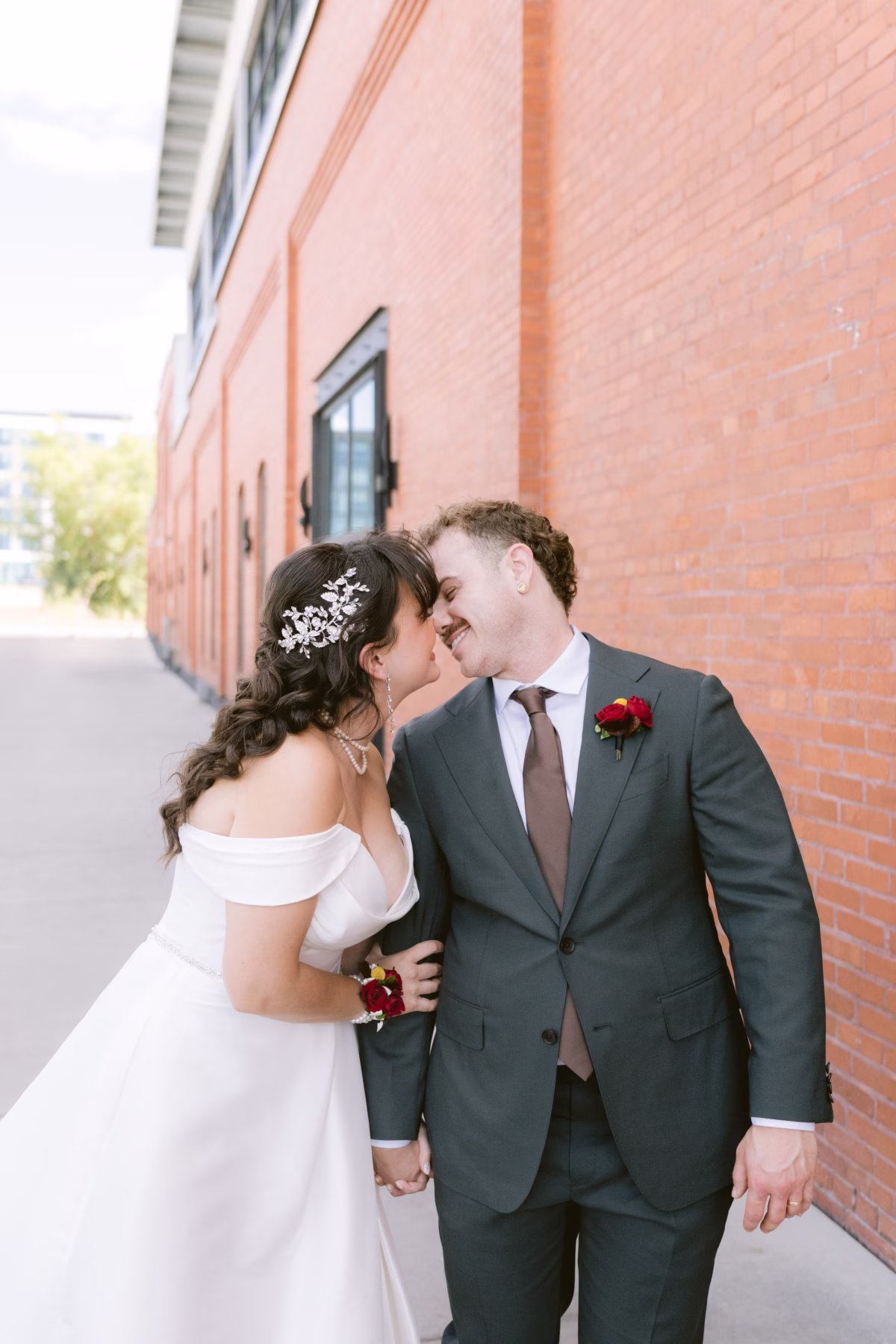 Bride and groom sharing intimate moment with red rose bouquet at Armature Works Tampa wedding planned by Seashine Weddings with florals by Events in Bloom