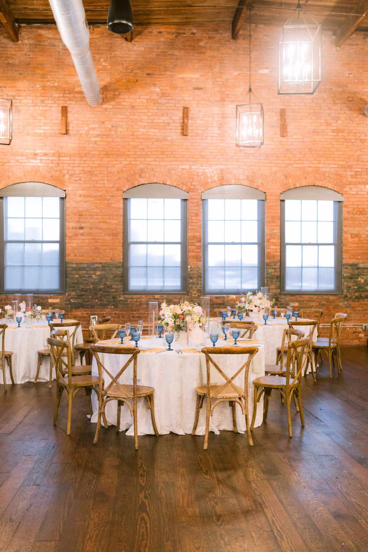 Elegant wedding reception with cross-back chairs and pink florals by I Dew Events at Armature Works Tampa captured by Ashley Izquierdo Photography