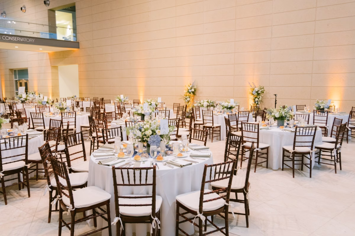 Elegant wedding reception at Nancy Cotto Events art museum venue in St. Petersburg with white floral centerpieces by Wonderland Floral Art and gold chiavari chairs