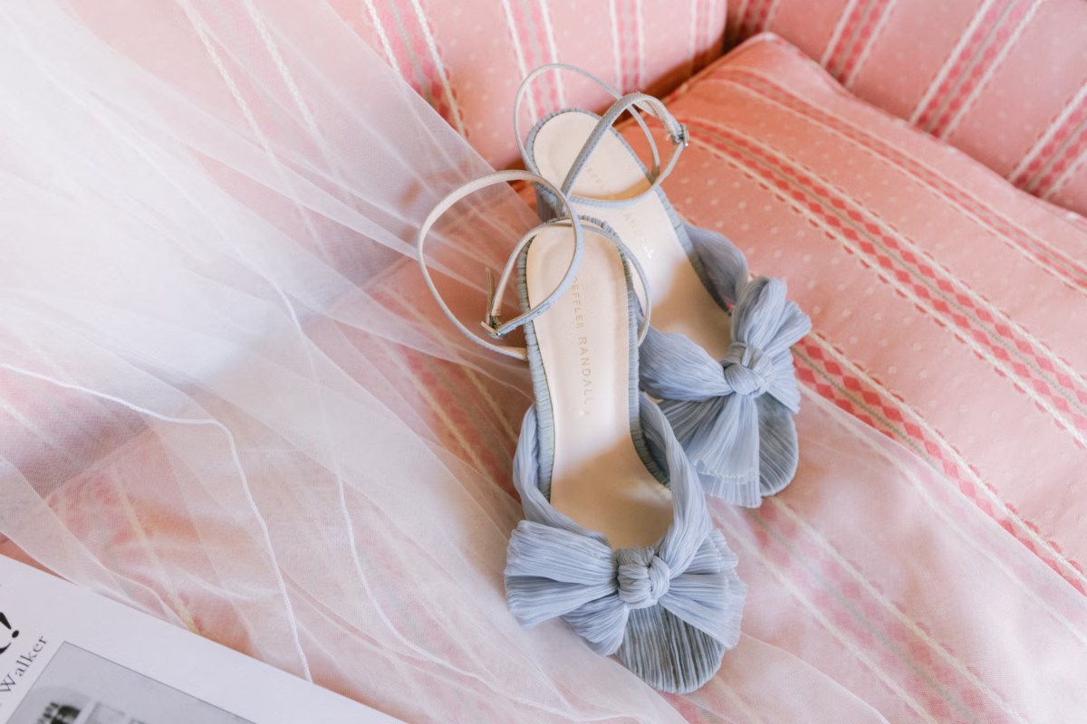 Blue bridal shoes with bow details on pink fabric for St. Pete Shuffleboard Club wedding photographed by Ashley Izquierdo Photography