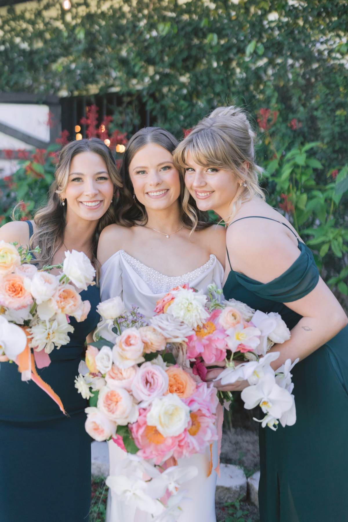 Bride with bridesmaids holding colorful bouquets by Golden Wild Florals at Soire Estate Tampa garden wedding
