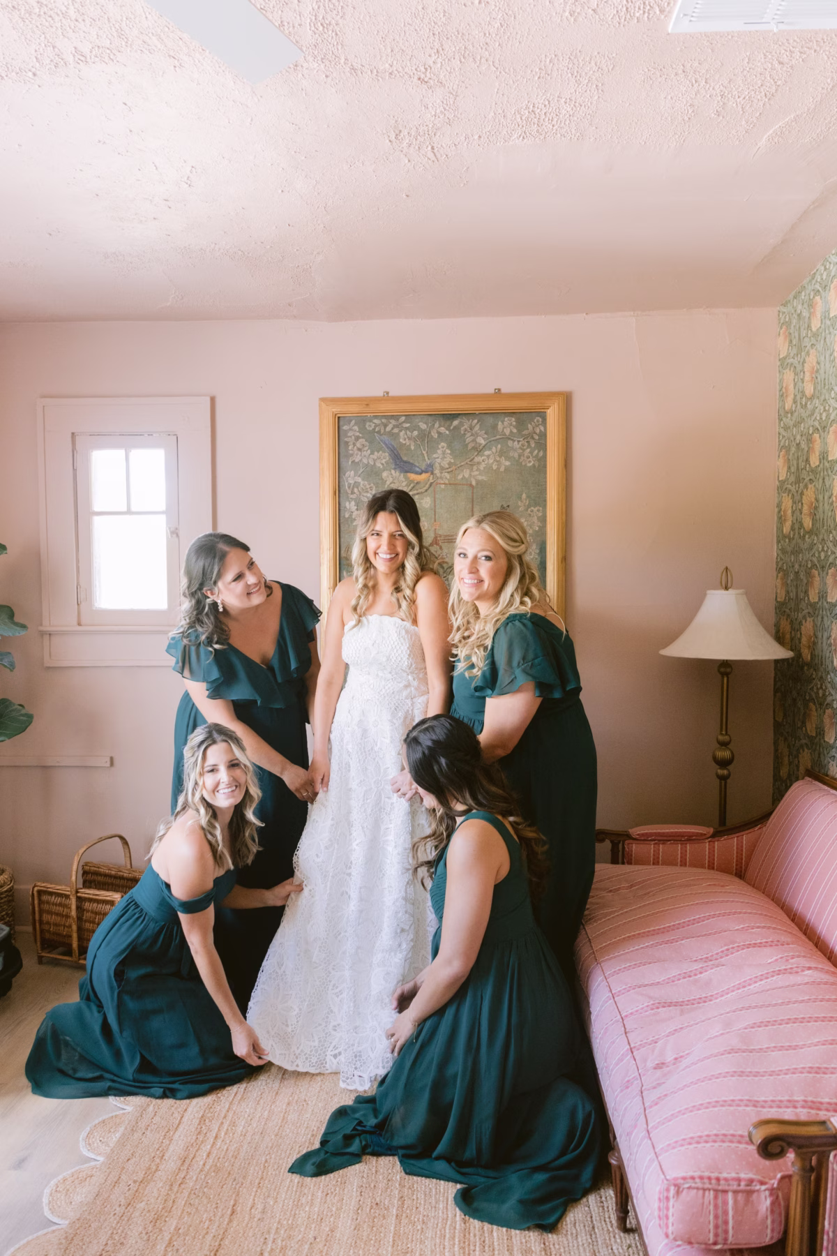 Bride in BHLDN wedding dress surrounded by bridesmaids in Birdy Grey emerald dresses during getting ready photos at Hostess House in St. Petersburg by Ashley Izquierdo Photography