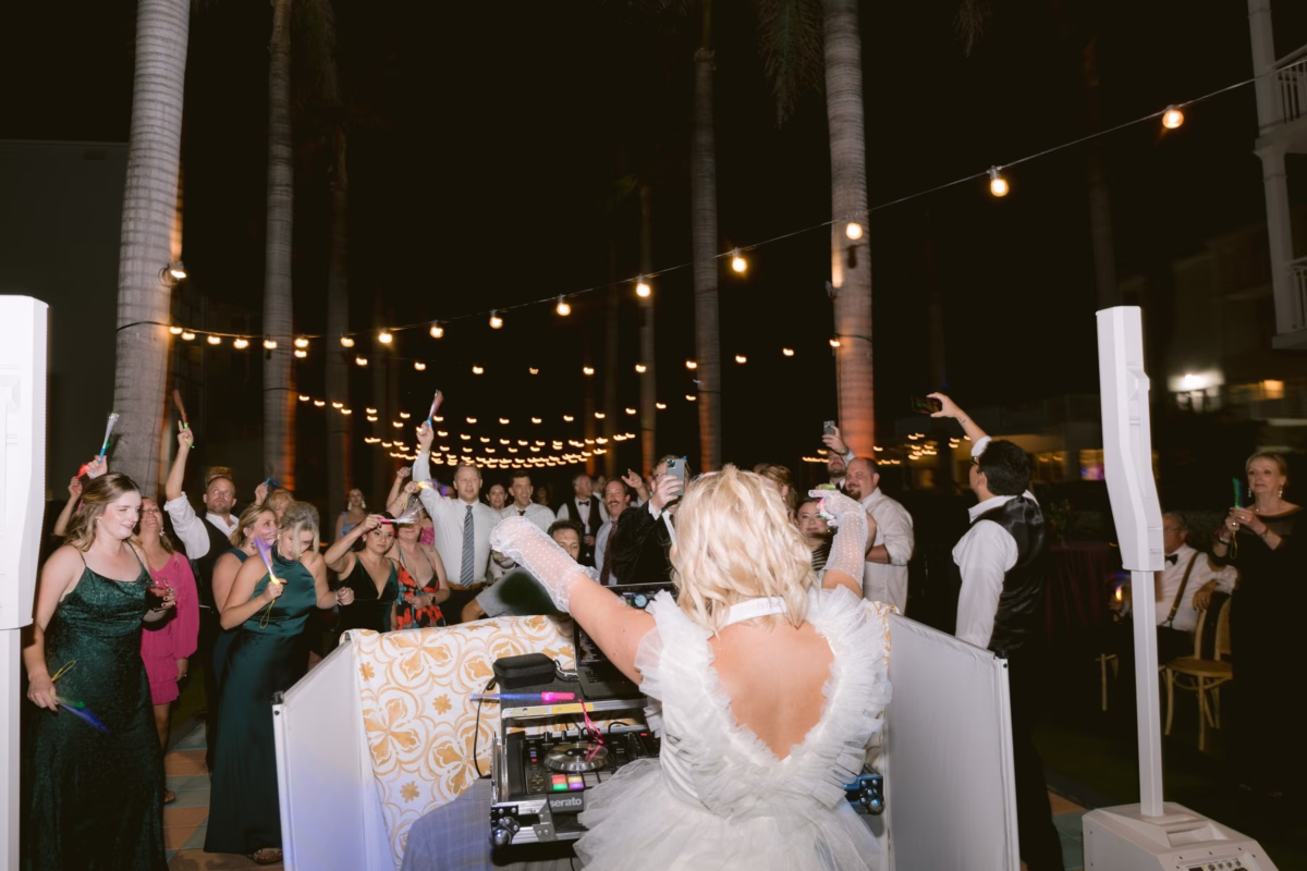 Bride DJing her own wedding reception with guests dancing under string lights at Casa Marina Key West with DJ Lira