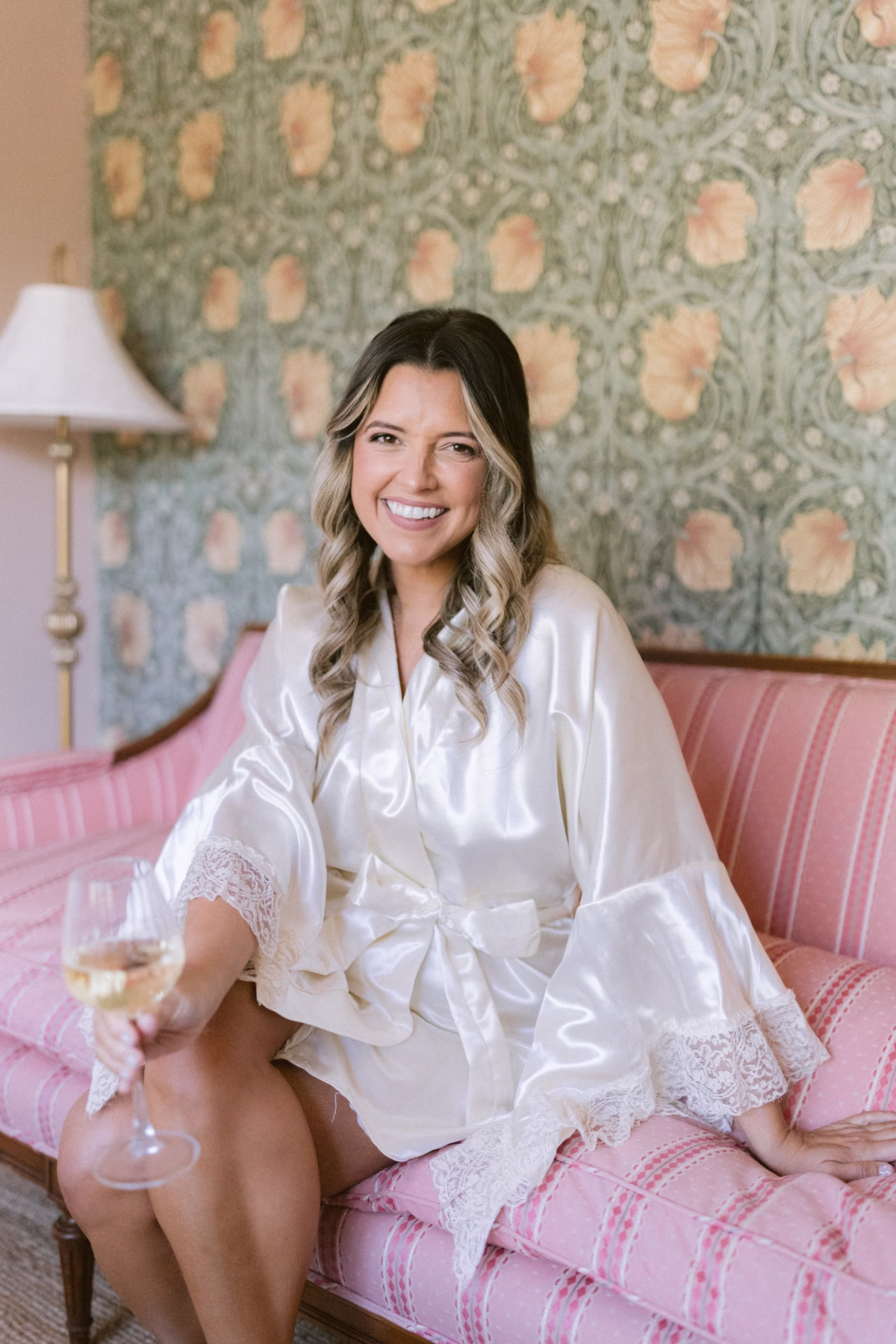 Bride in white silk robe holding champagne during getting ready at Hostess House for St Pete Shuffleboard Club wedding photographed by Ashley Izquierdo Photography