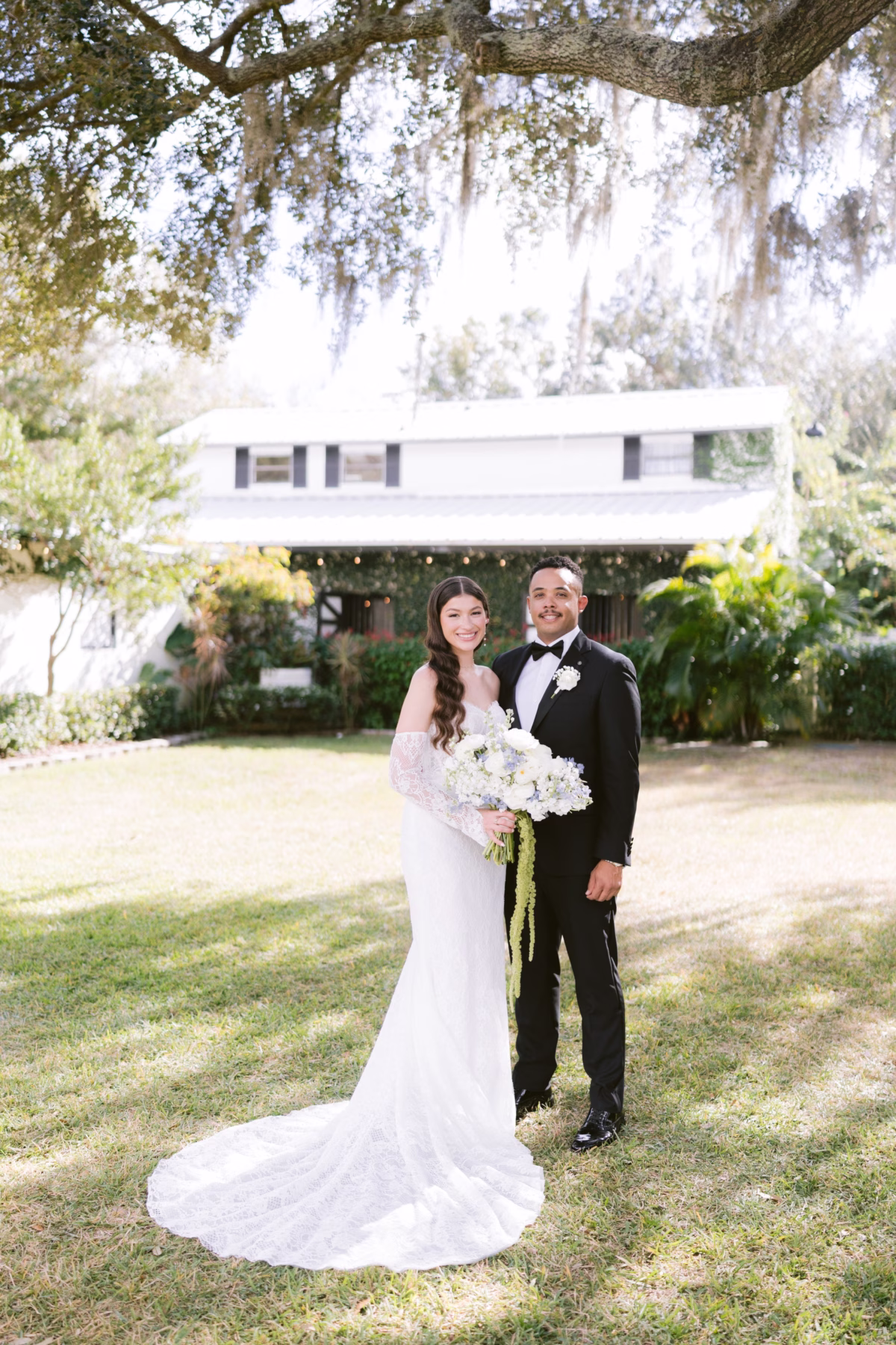 Bride in Ella Blu Bridal gown with Ava Elise Decor florals and groom in black tuxedo at Soire Estate Tampa wedding