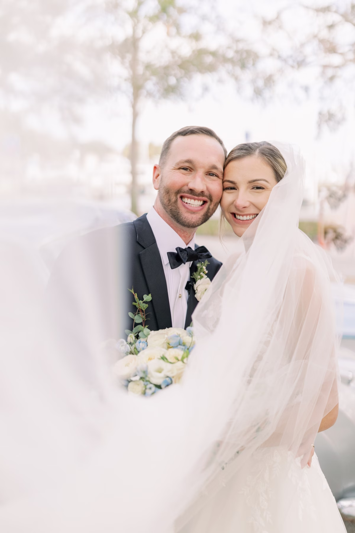 Bride and groom portrait with white and blue bridal bouquet by Lemon Drops Weddings and Events at The Vinoy St. Petersburg waterfront wedding