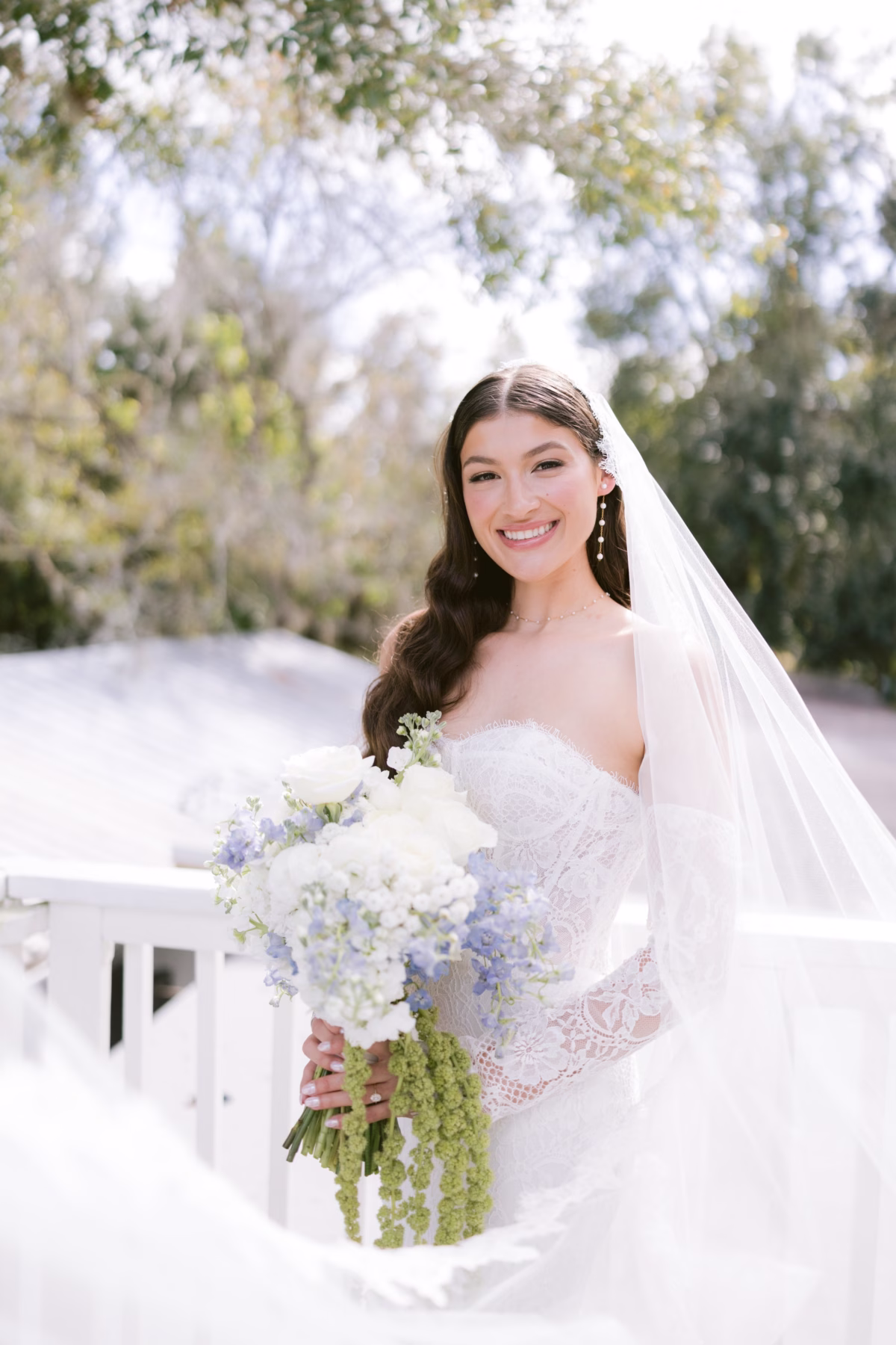 Elegant bride in wedding dress holding white and blue bouquet by Ava Elise Decor at Soire Estate Tampa wedding