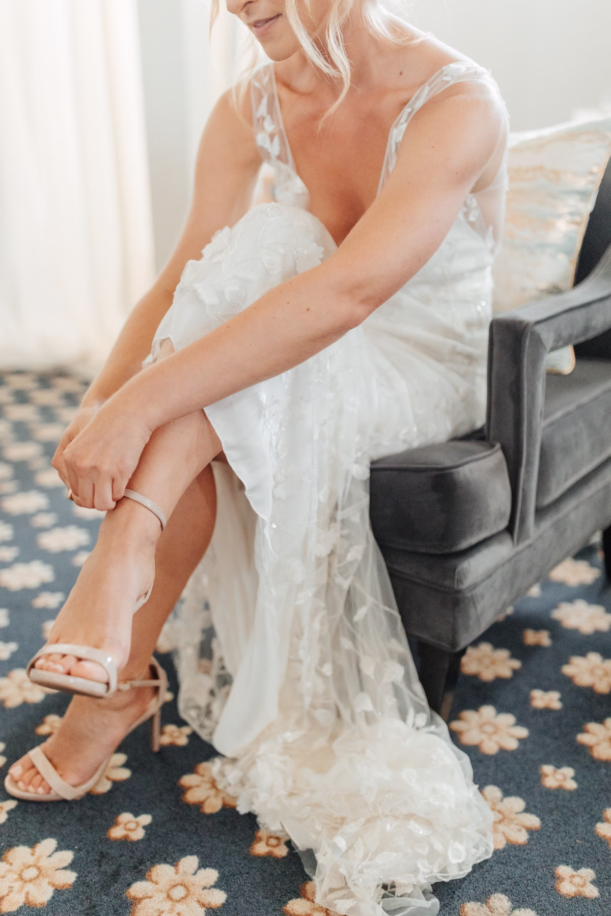 Bride in Alexandra Grecco wedding dress putting on bridal shoes at historic Lightner Museum wedding in St Augustine