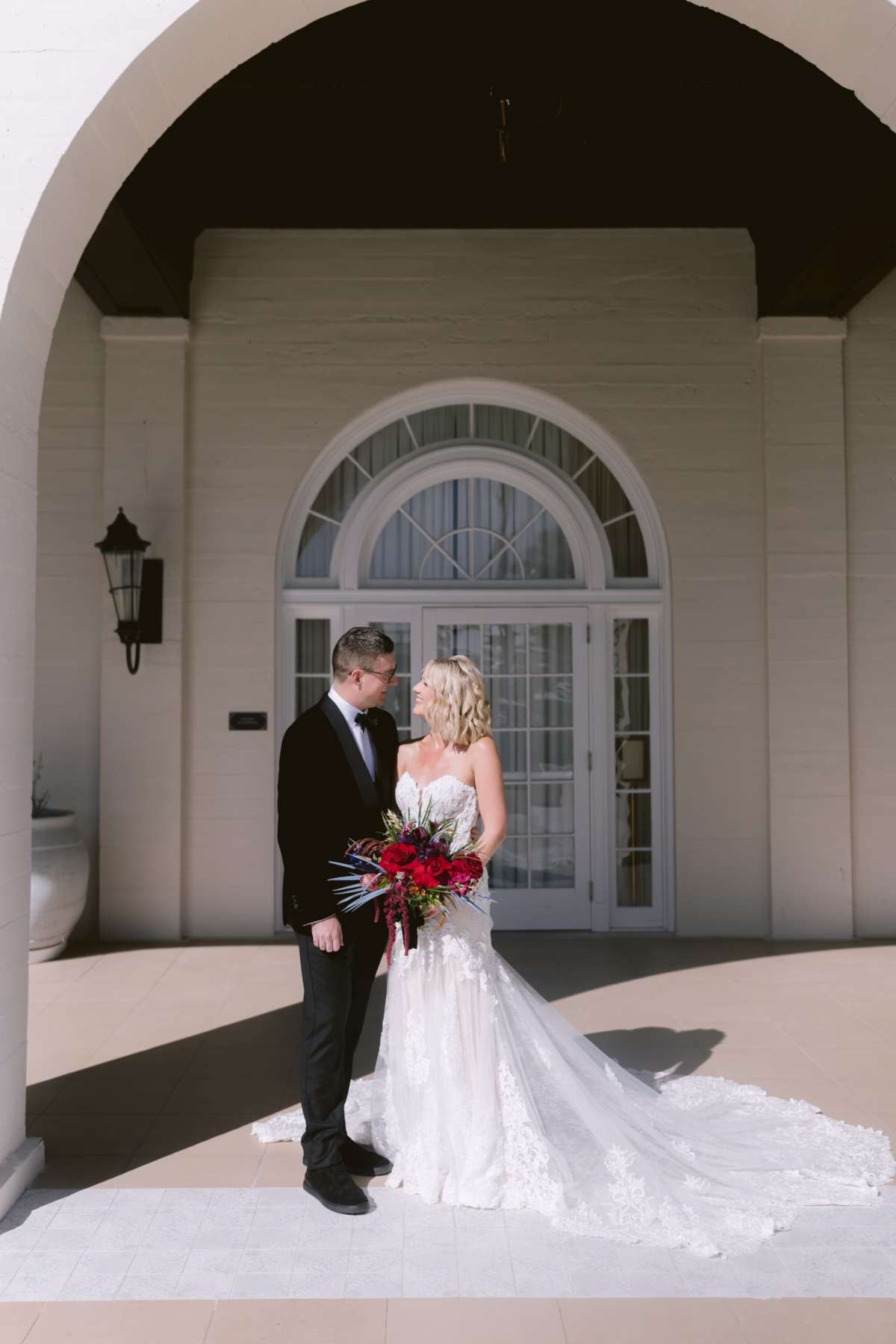 Elegant wedding couple portrait at Casa Marina Key West featuring stunning red bouquet by Arms of Persephone florist
