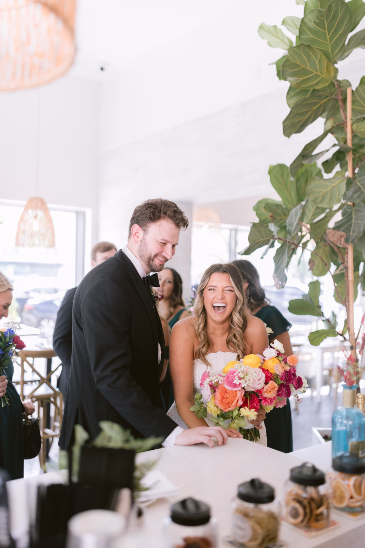 Bride and groom laughing with vibrant colorful bridal bouquet by Petite Fleur at St Pete Shuffleboard Club wedding