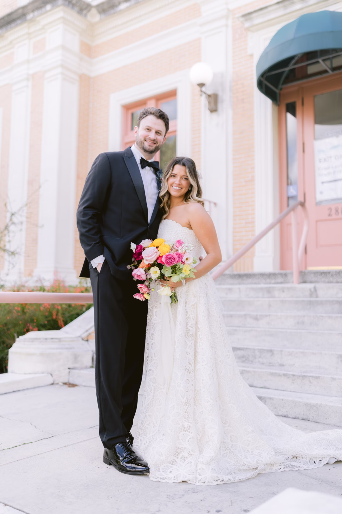 Bride and groom with vibrant colorful wedding bouquet by Petite Fleur at St Pete Shuffleboard Club wedding photographed by Ashley Izquierdo Photography