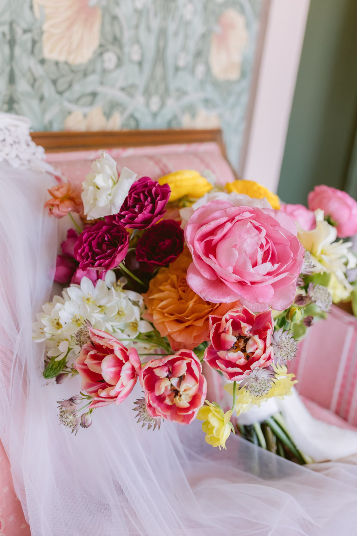Vibrant spring wedding bouquet with pink ranunculus, burgundy dahlias and white flowers by Petite Fleur at St Pete Shuffleboard Club wedding photographed by Ashley Izquierdo Photography