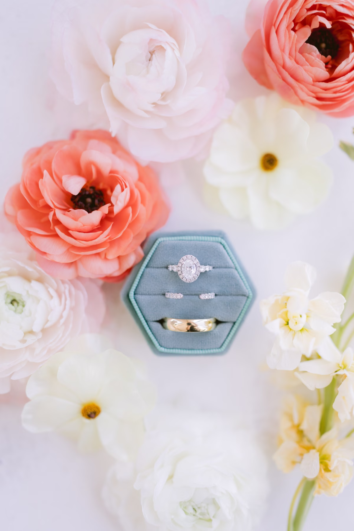 Elegant wedding ring flat lay with coral ranunculus and white flowers by I Dew Events for Tampa Bay wedding at Armature Works