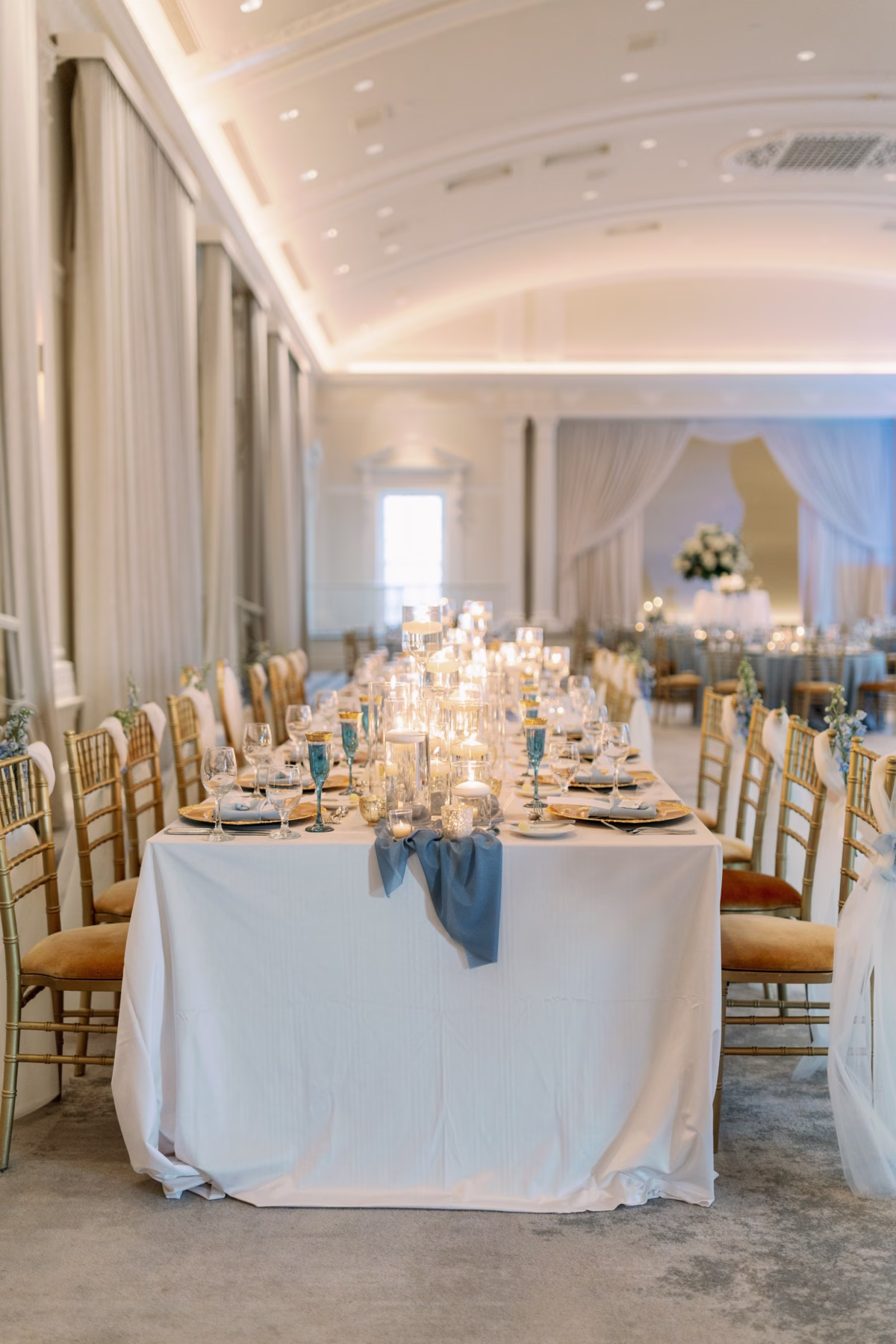 Elegant white and blue wedding reception tablescape with gold chiavari chairs and candles at The Vinoy St. Petersburg by Lemon Drops Weddings and Events