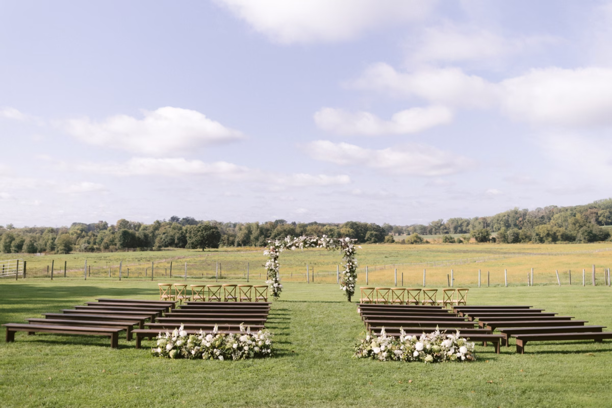 florist allie johnson ceremony setup johnsons locust hall farm wedding - A Farm Wedding at Johnson's Locust Hall, New Jersey Outdoor wedding ceremony setup with wooden benches and floral arch by Allie Johnson at Johnson's Locust Hall farm venue in New Jersey