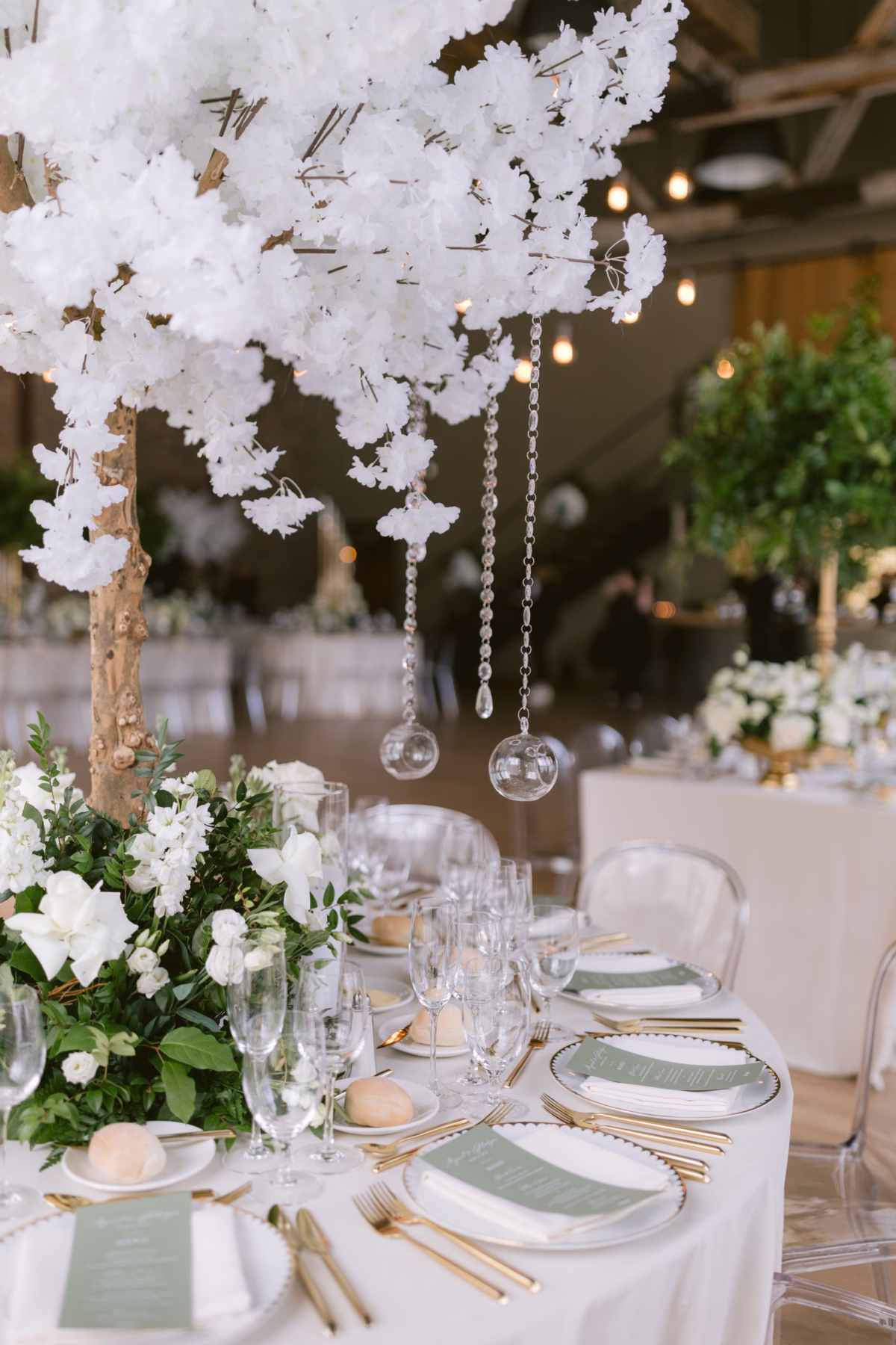 Elegant white floral centerpiece with hanging glass orbs by Maky The Diva Flowers at The Roundhouse Beacon wedding reception