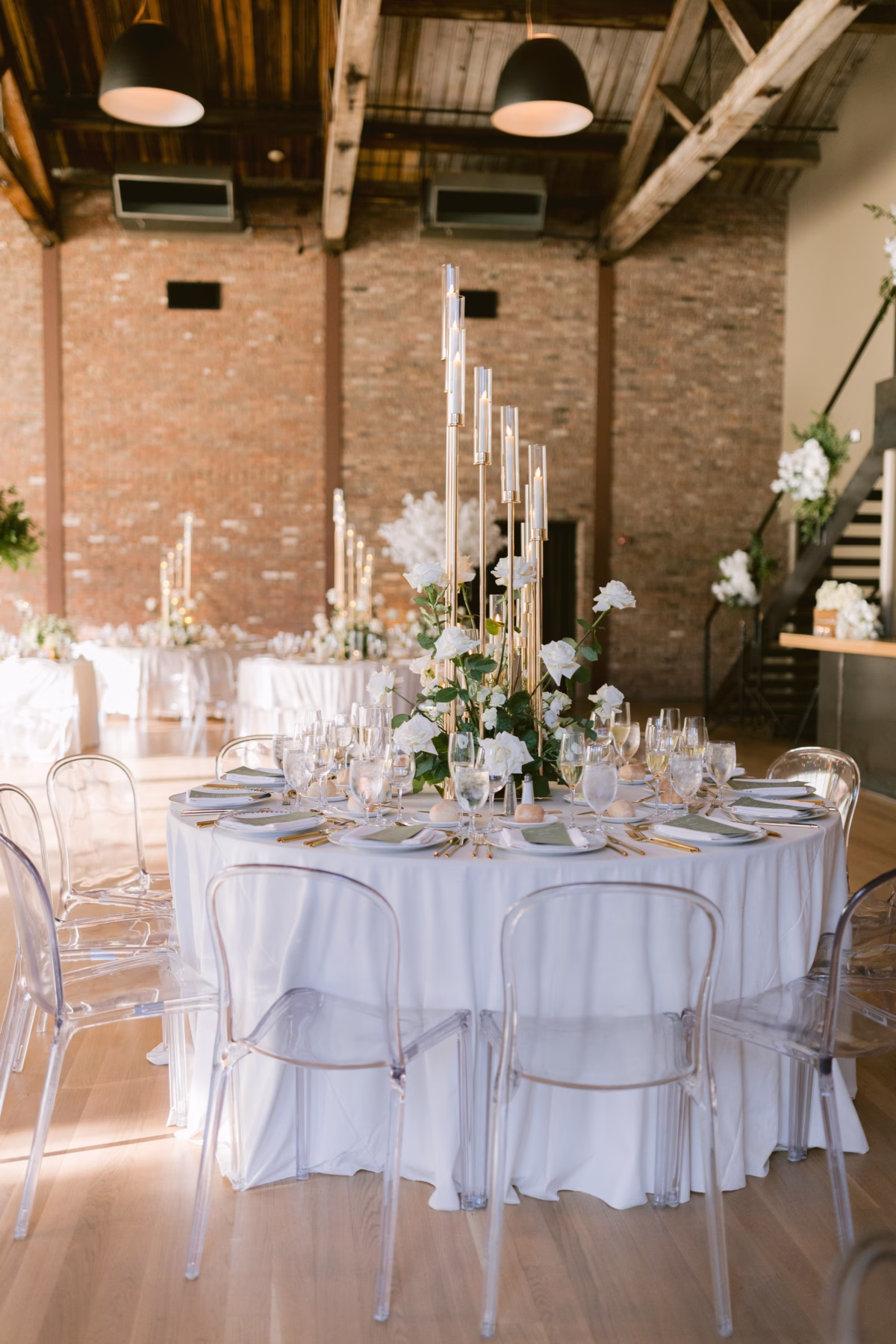 Elegant wedding reception table with tall glass tube centerpieces and white florals by Maky The Diva Flowers at The Roundhouse Beacon venue